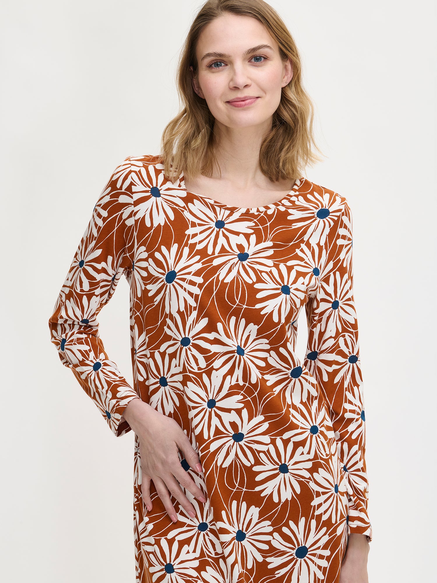 Women’s floral print Anette nightgown with long sleeves and a round neckline in brown on a model in a close-up picture.