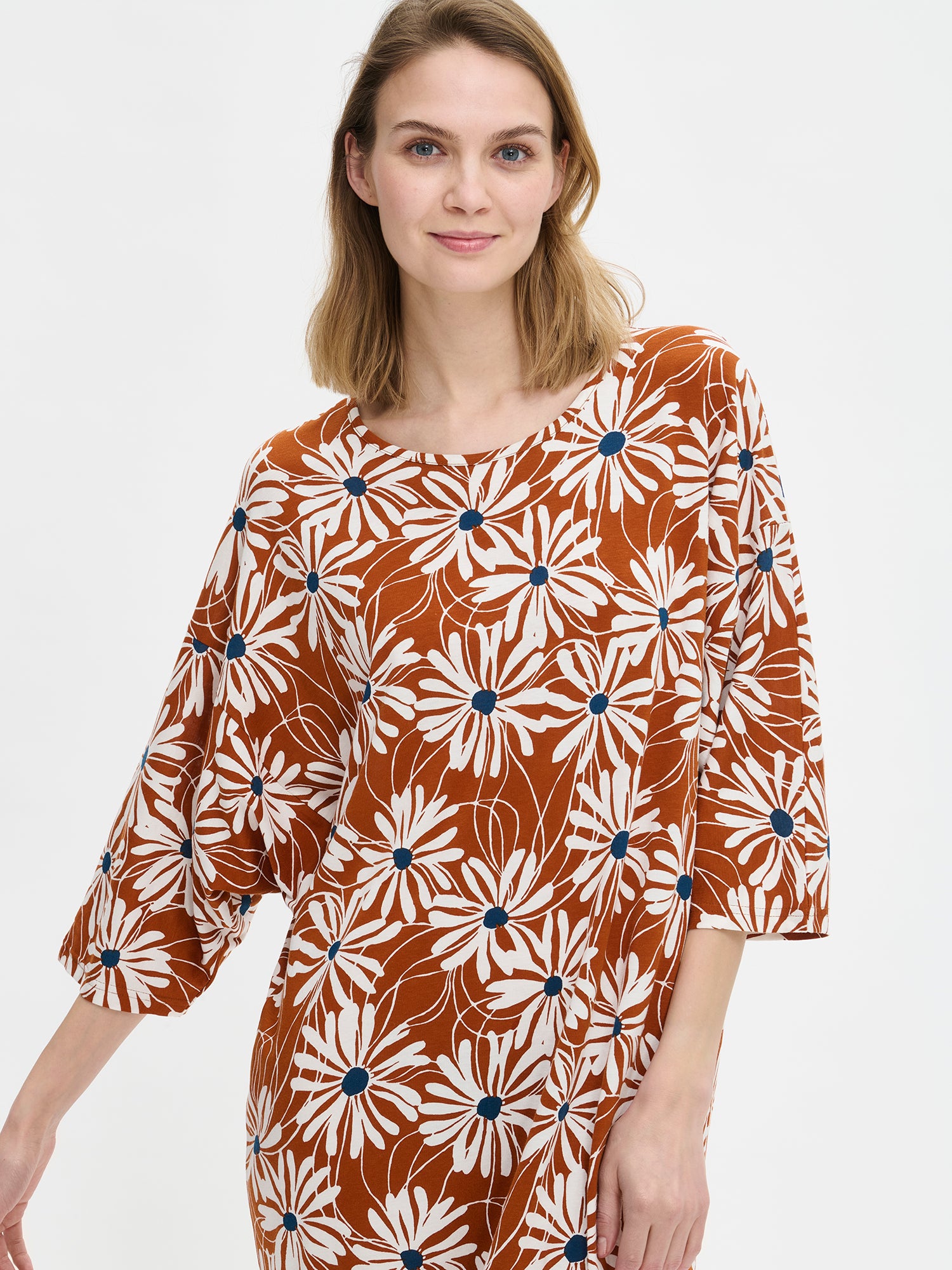 Brown Anette kaftan with a dropped sleeve and a relaxed neckline on a model in a close-up photo.