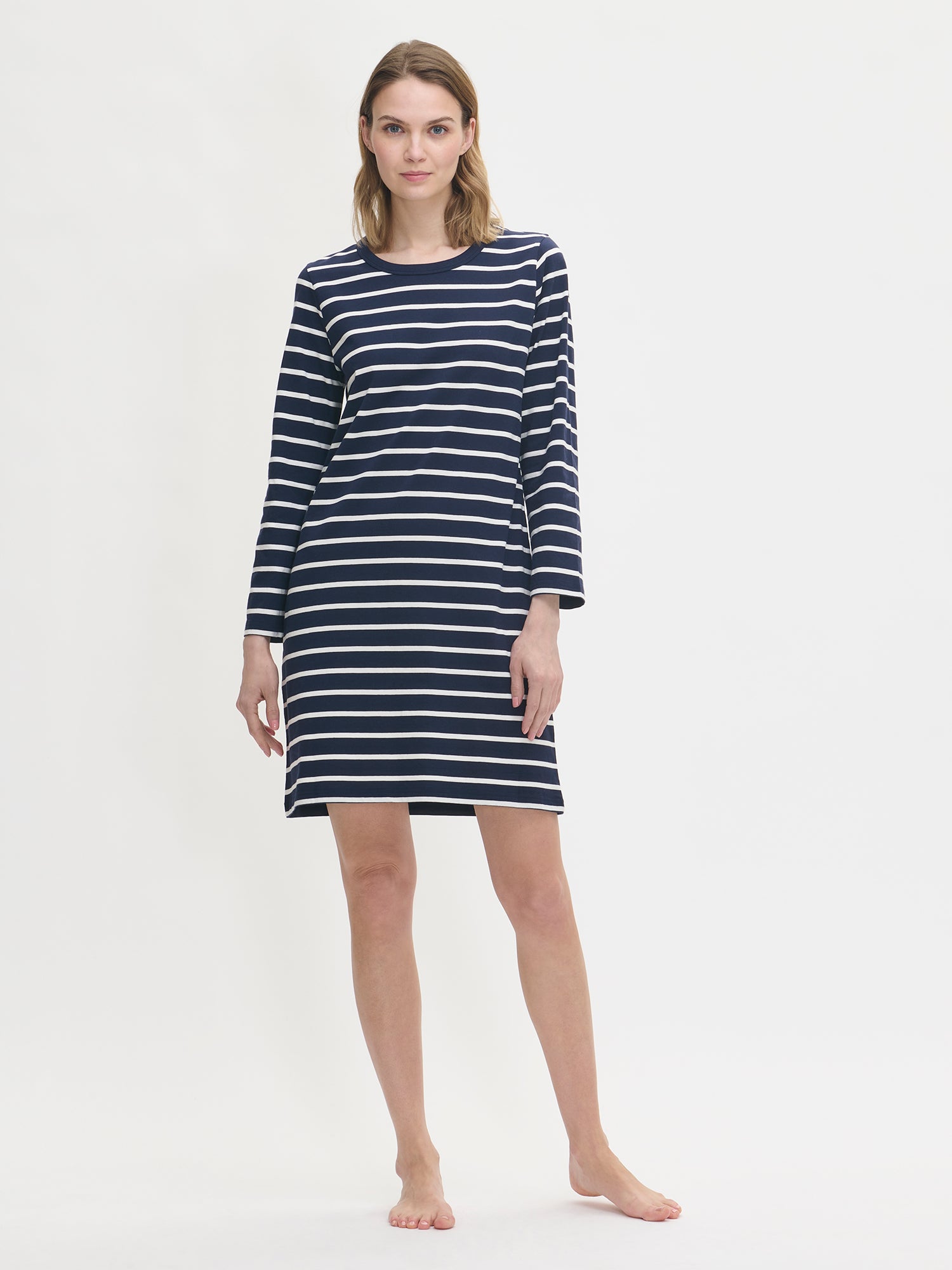 Women’s nightgown Duetto with blue and white stripes has long sleeves and a round neckline. The nightgown is worn by a model in the picture.