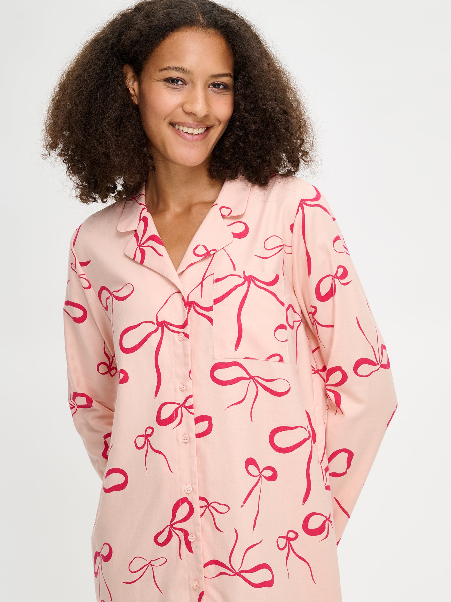 The Rusetti nightgown has a bow pattern on it. Here the nightgown on a model in a close-up picture.