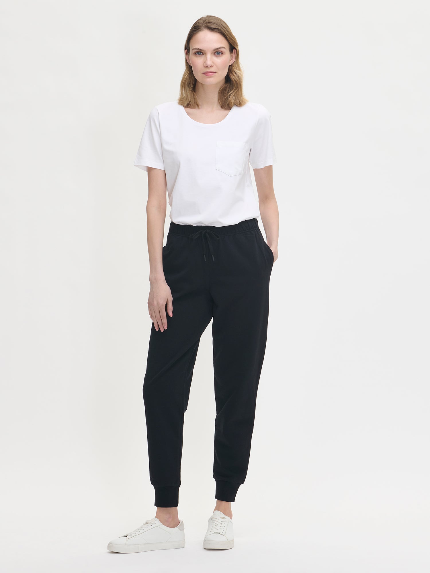Women's black Koto sweatpants in featuring side pockets on a model.
