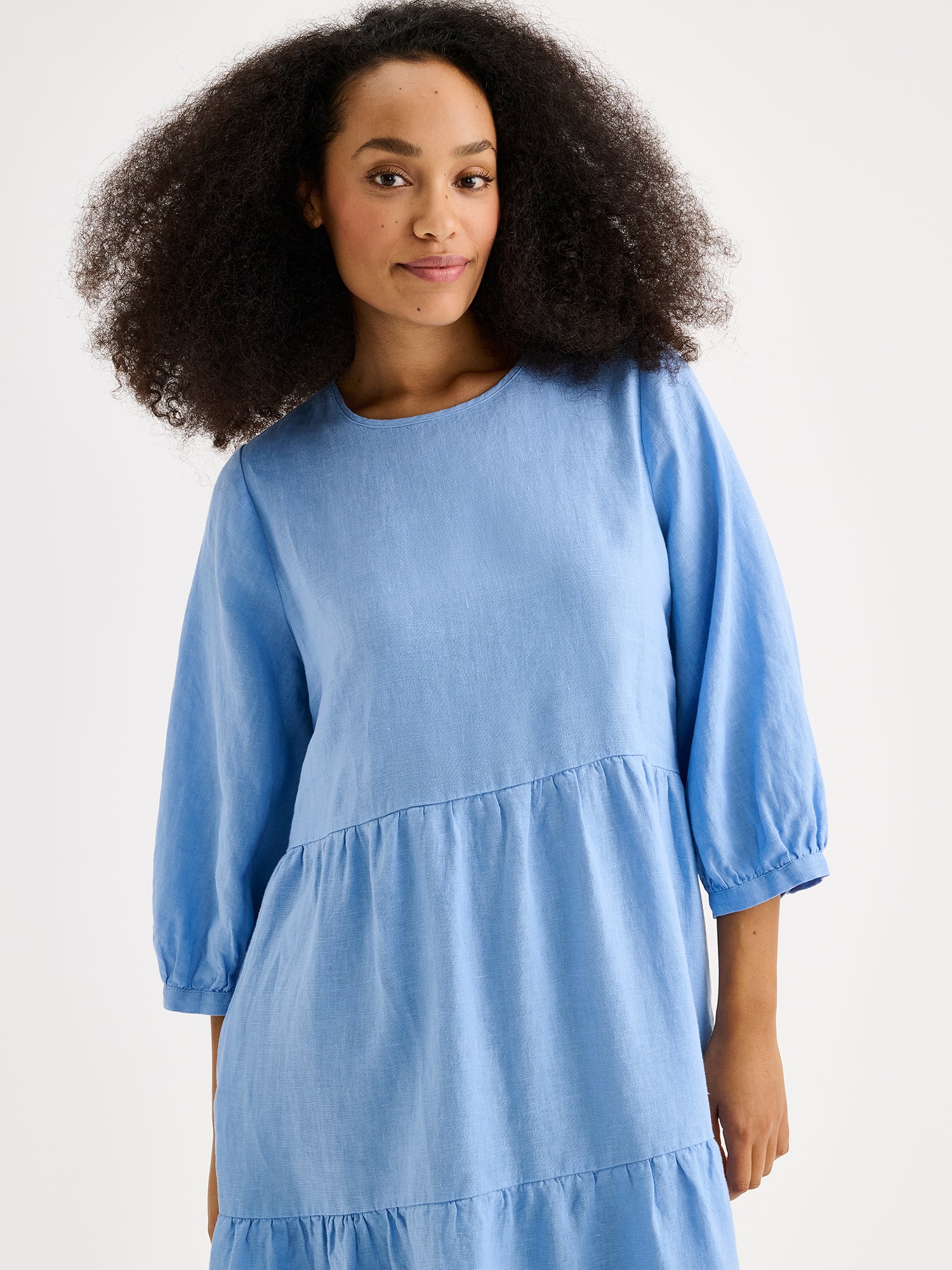 Nanso women's Saralia Linen Dress in blue with voluminous frill layers on a model, close-up.