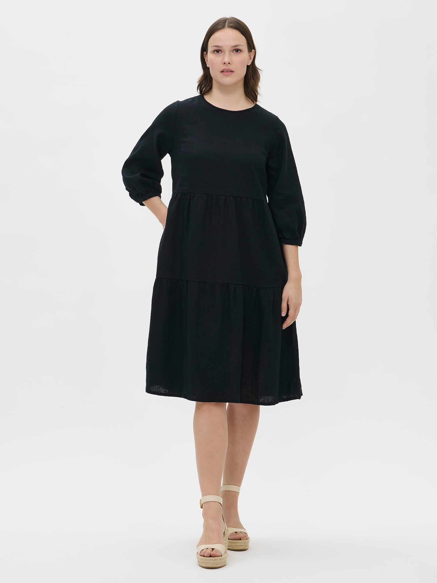 Women's Saralia Linen Dress in black features voluminous frill layers, making it a stylish staple for spring and summer. Worn by a model in size S.