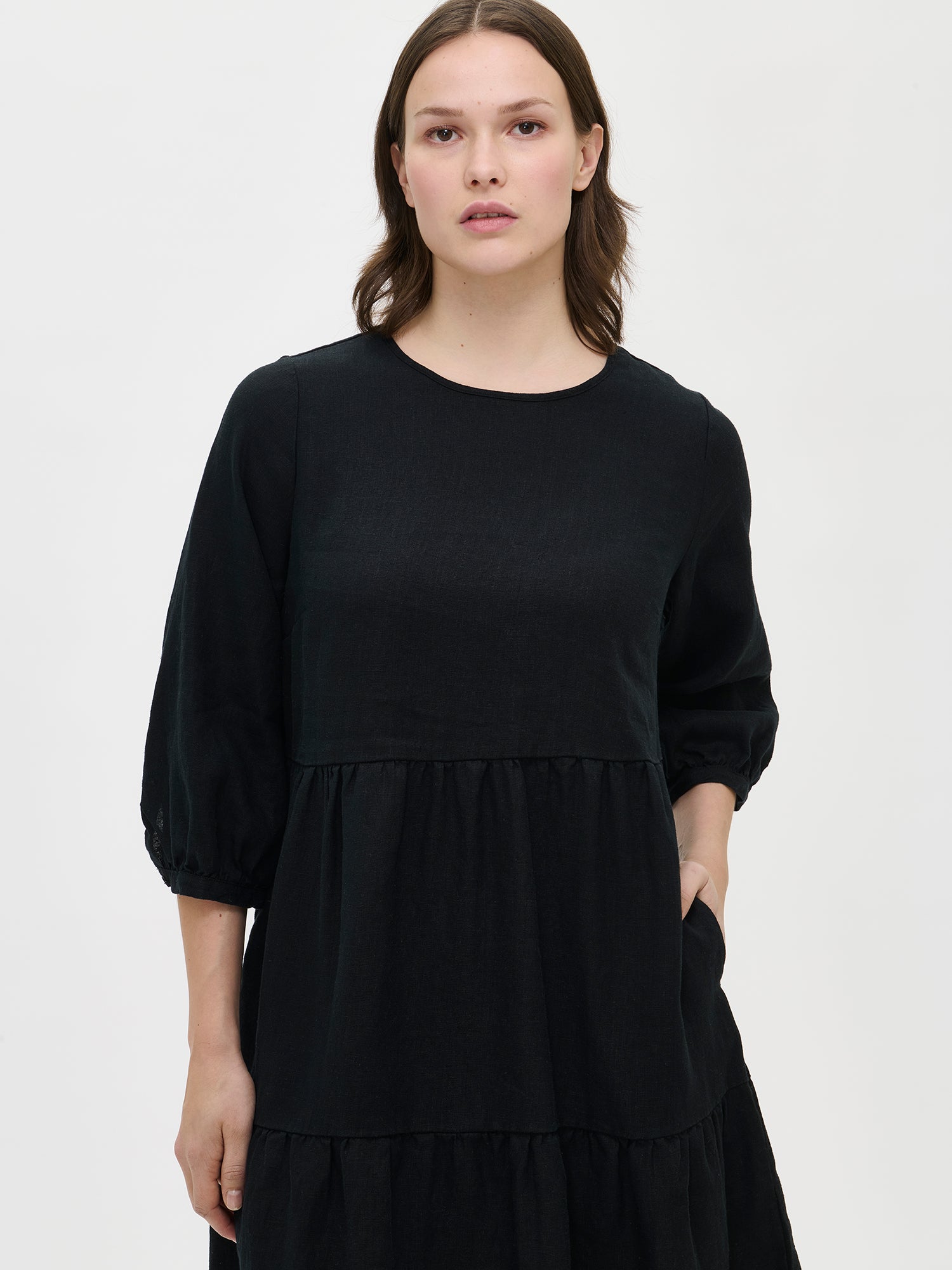 Women's Saralia Linen Dress in black features voluminous frill layers, making it a stylish staple for spring and summer. Worn by a model in size S.