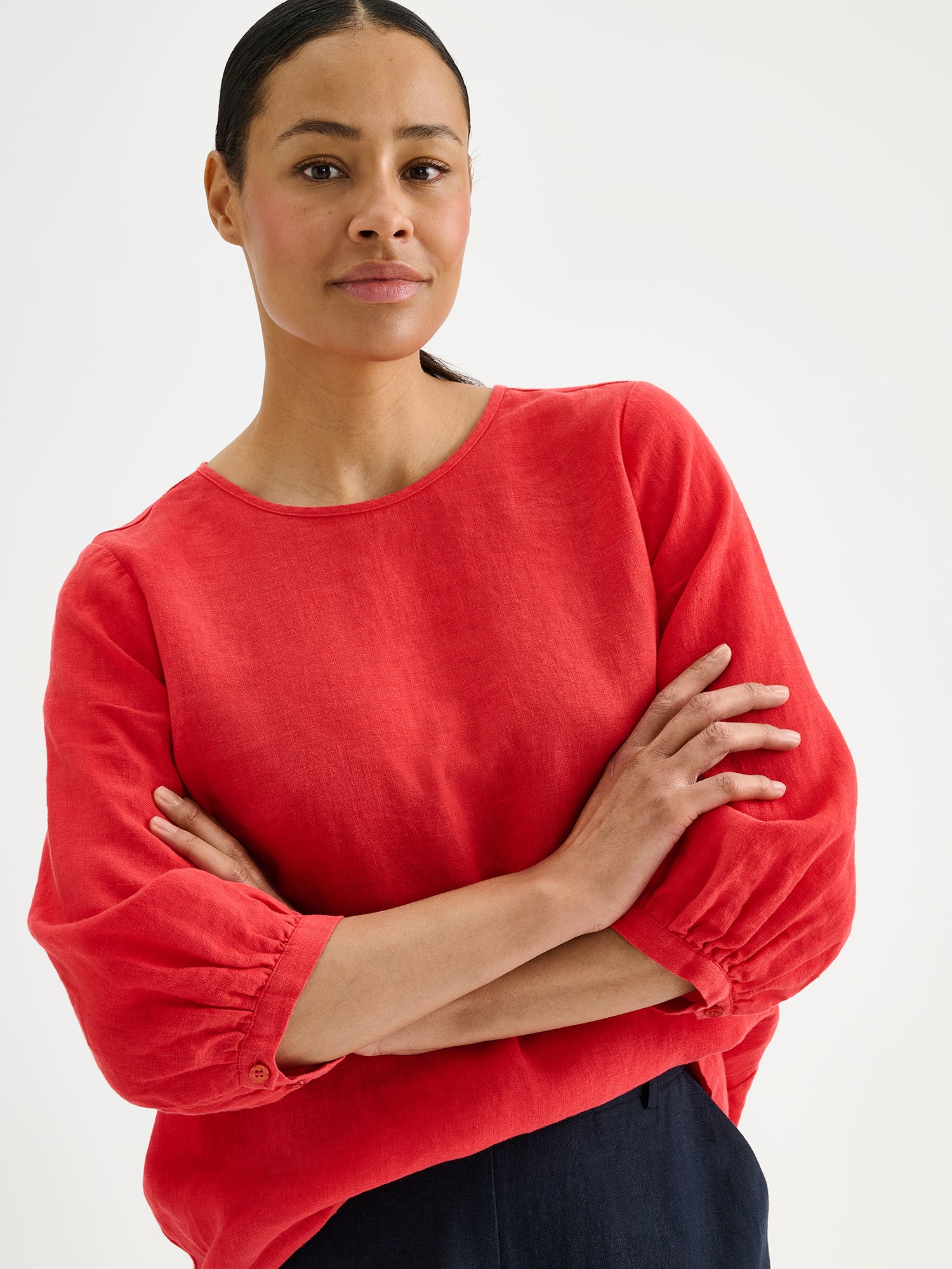 Nanso women's Saralia linen Blouse in red on a model with dark linen trousers, close-up.