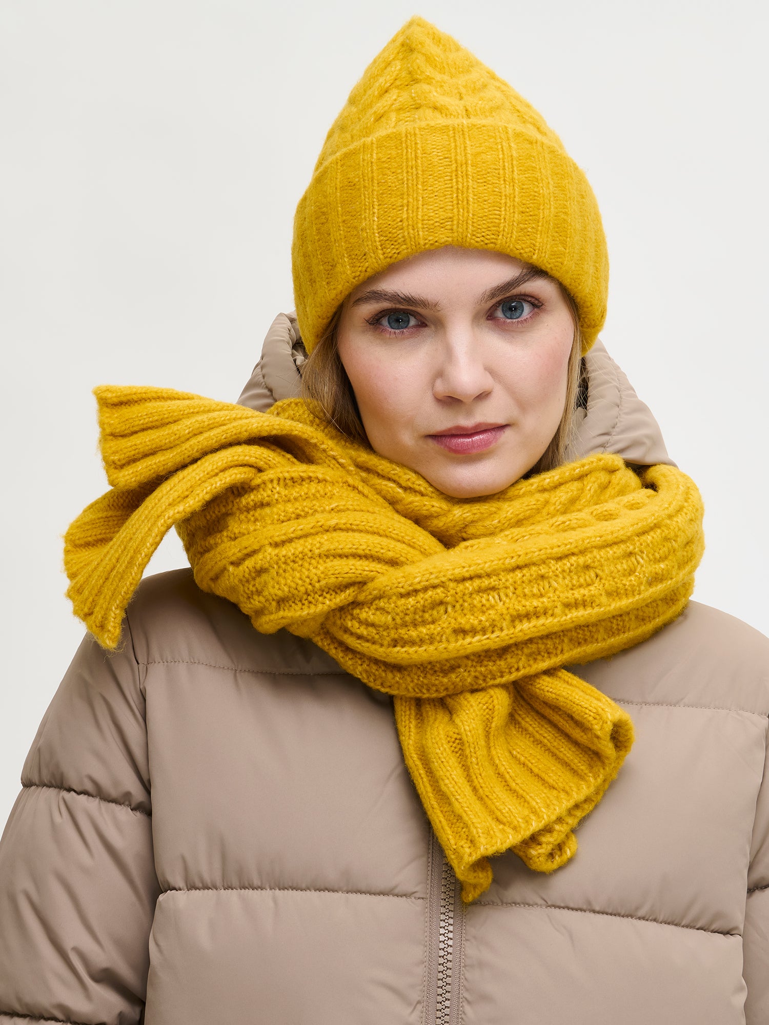 Nanso women’s yellow Kierre knit beanie features a charming cable pattern and a cozy, voluminous fit