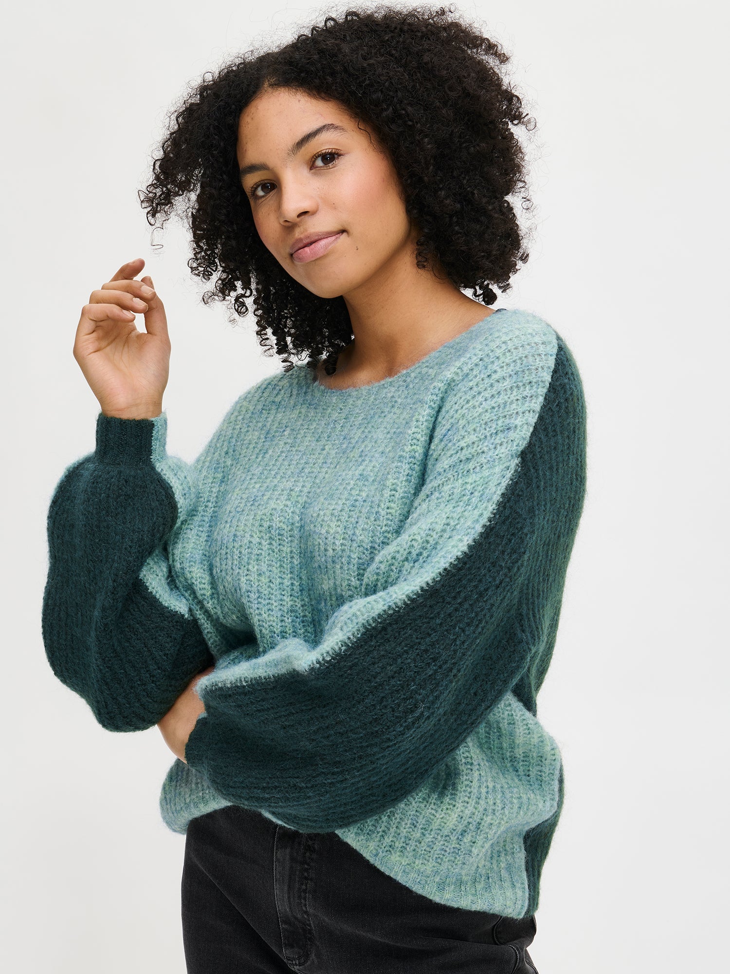 Nanso Women's luxurious green Karamelli knit sweater with contrasting green colors, on a model, close-up.