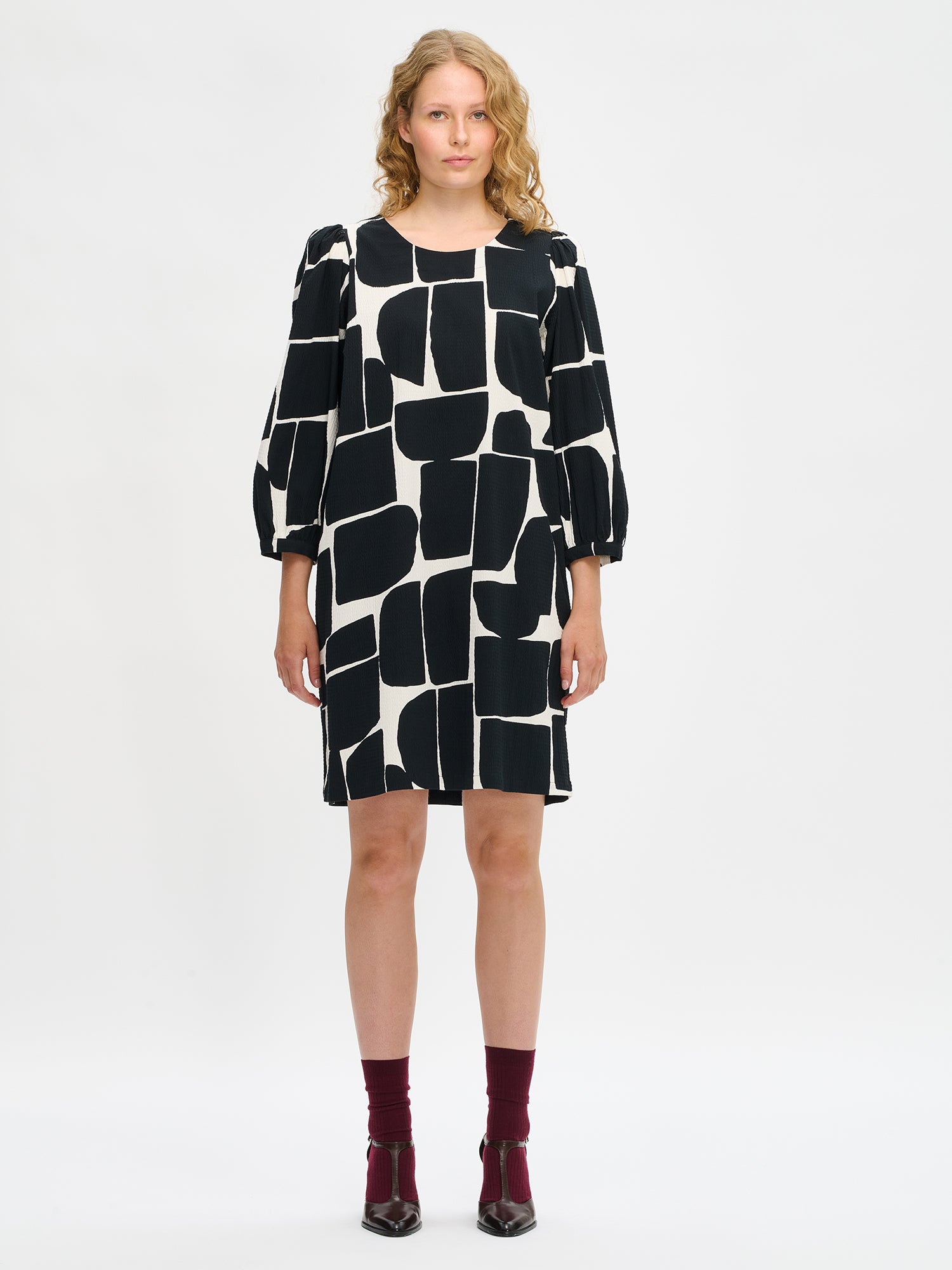 Nanso women’s black and white patterned Muuri dress in cotton blend, round neckline and gathered sleeves, worn by model in full-body view.