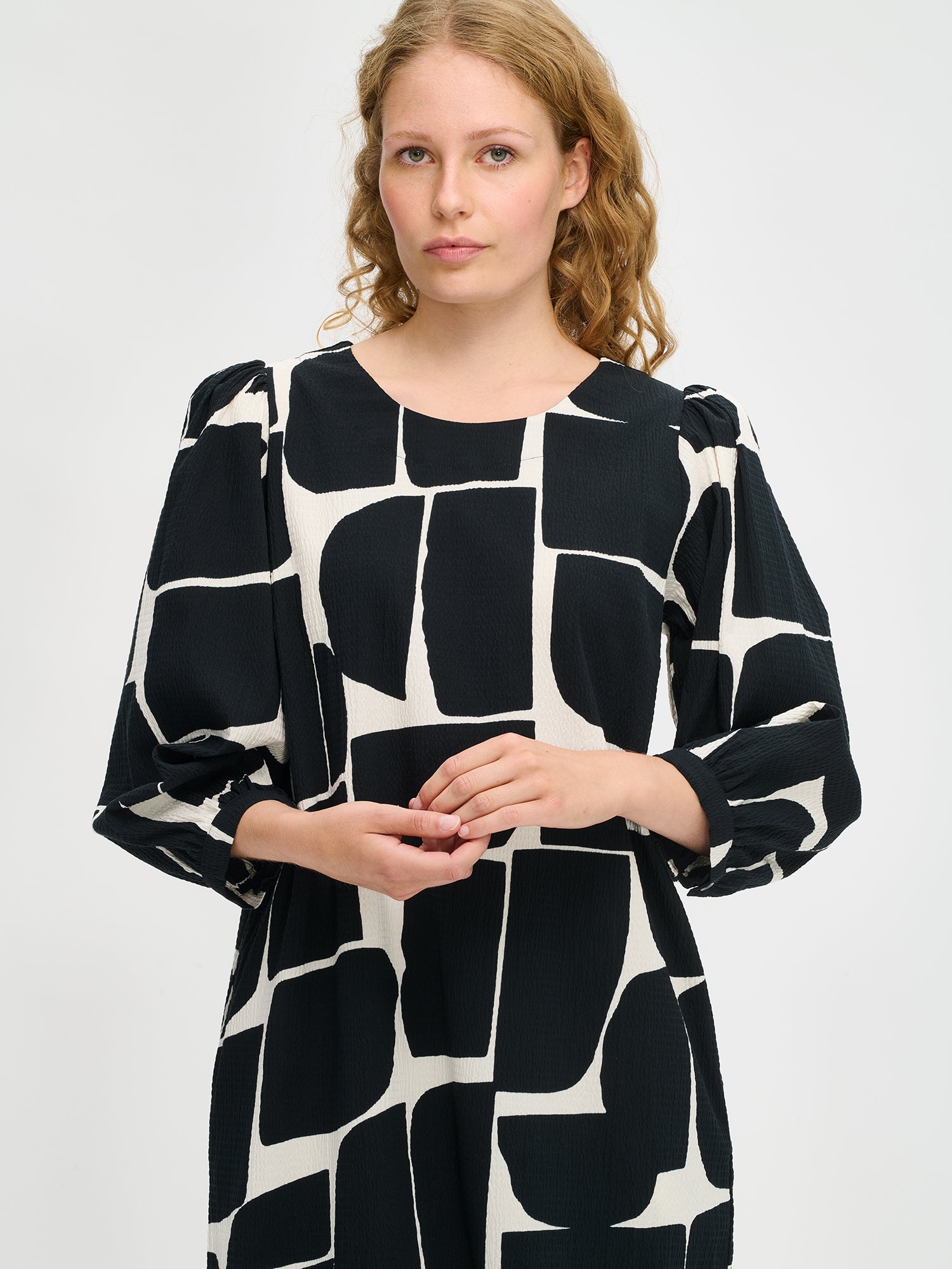 Nanso women’s black and white patterned Muuri dress in cotton with elastane, round neckline and pockets, worn by model in close-up view.