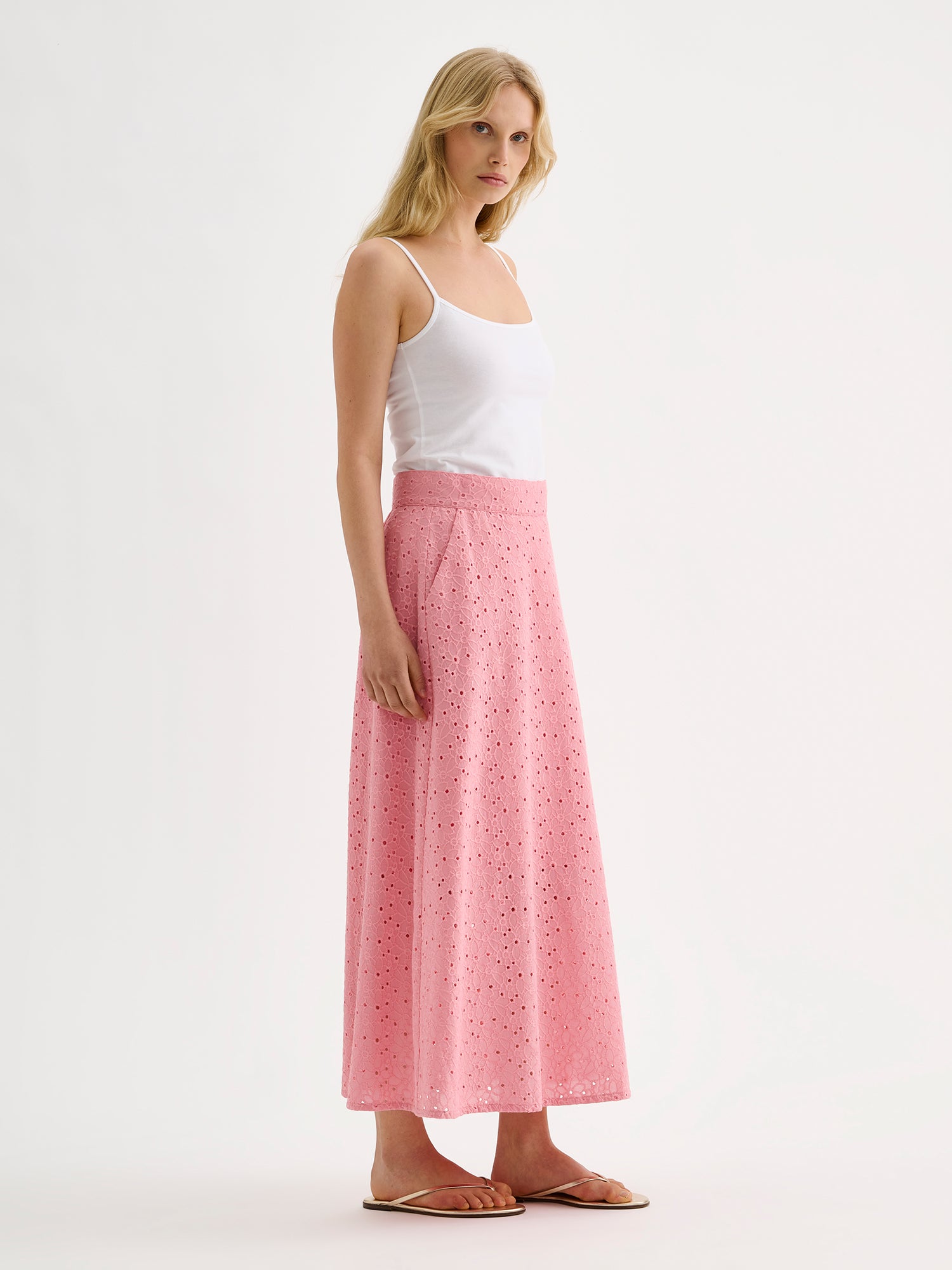 Nanso women's embroidered NUPPU Skirt in light pink featuring a broderie anglais style lace fabric on a model with a white top, pictured from the side