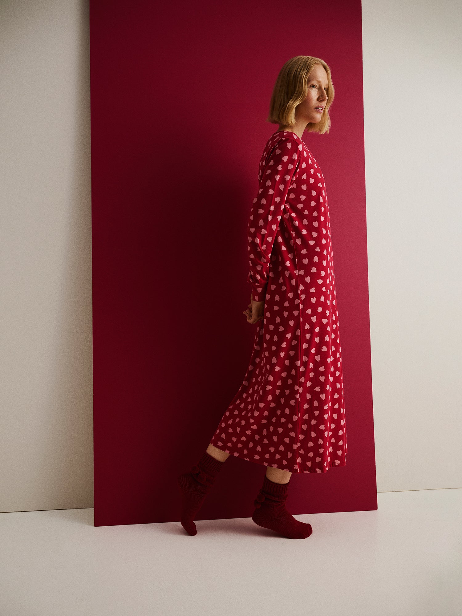 Nanso women's Amor long nightgown features a charming pattern with long sleeves and a round neckline, on a model pictured from the side.