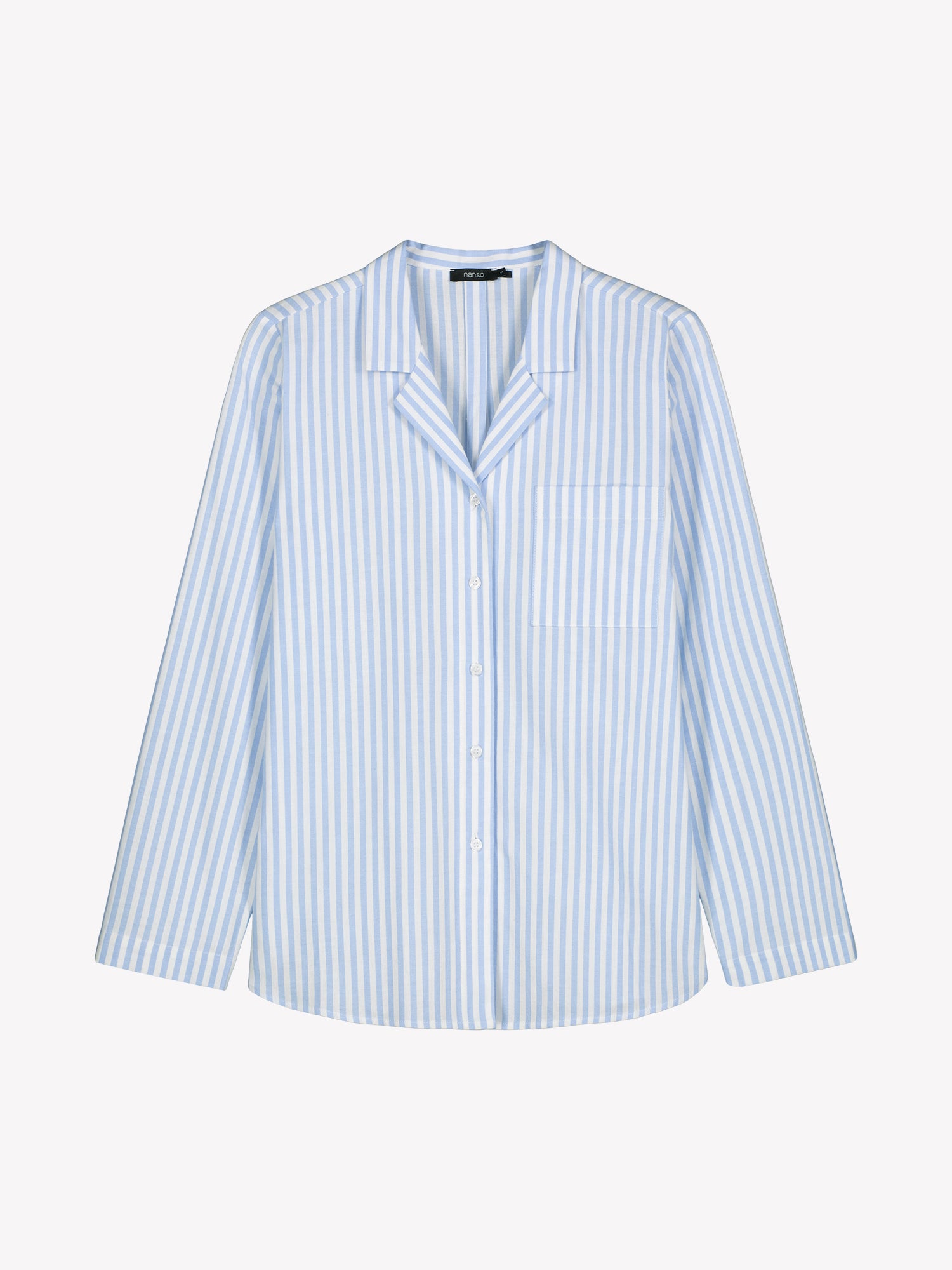 The Polka shirt, which features long sleeves, a beautifully shaped collar, a button stand, and a rounded hem, in a product picture.