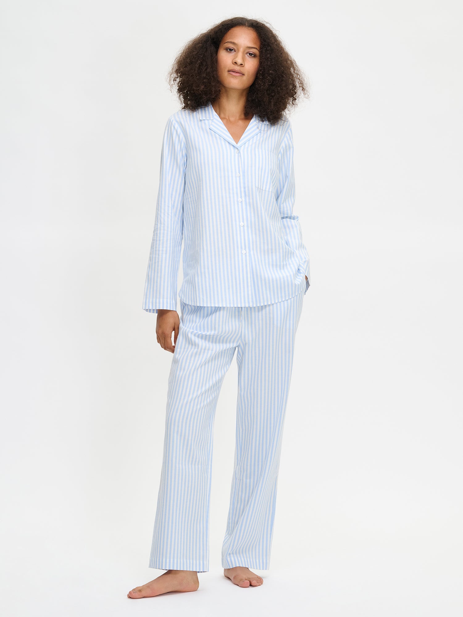 Women's striped light blue Polka pajama pants with matching long-sleeved shirt on a model.