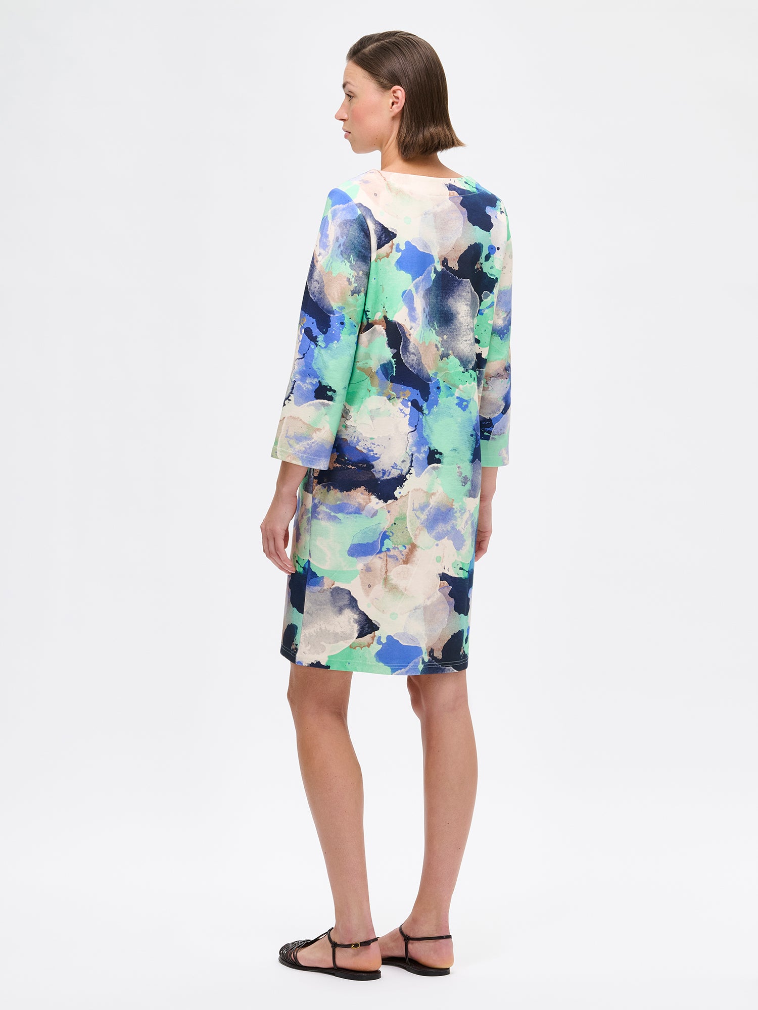 Women's SIRIUS Dress with a beautiful abstract pattern and a clean, minimalist cut that lets the beautiful pattern take center stage. The dress features 3/4 sleeves and pockets. Pictured on a model from the back.