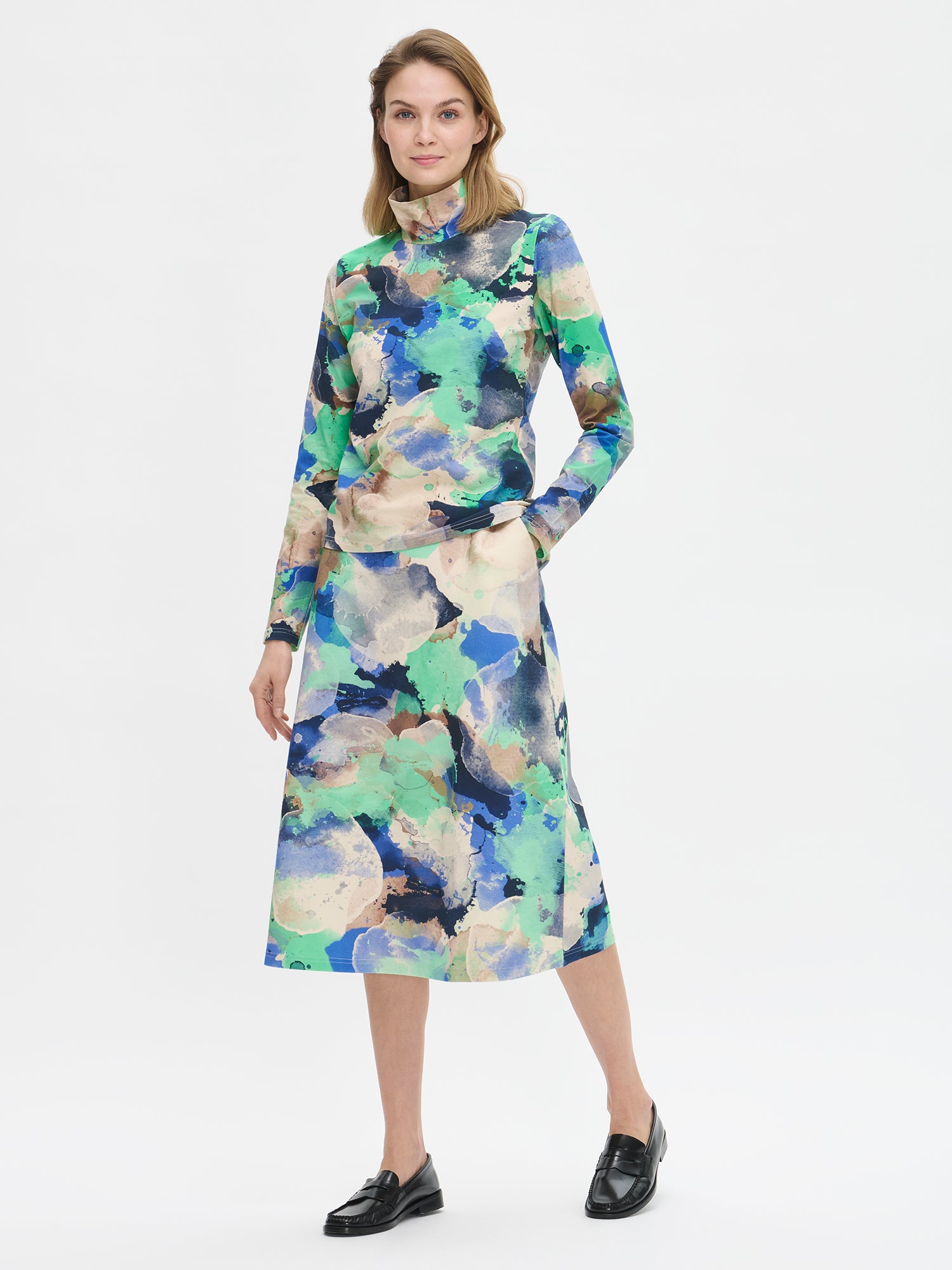 Women's SIRIUS Skirt with a beautiful abstract pattern and flattering A-line silhouette for comfort and style, while practical pockets add everyday functionality. Pictured on a model from the front.