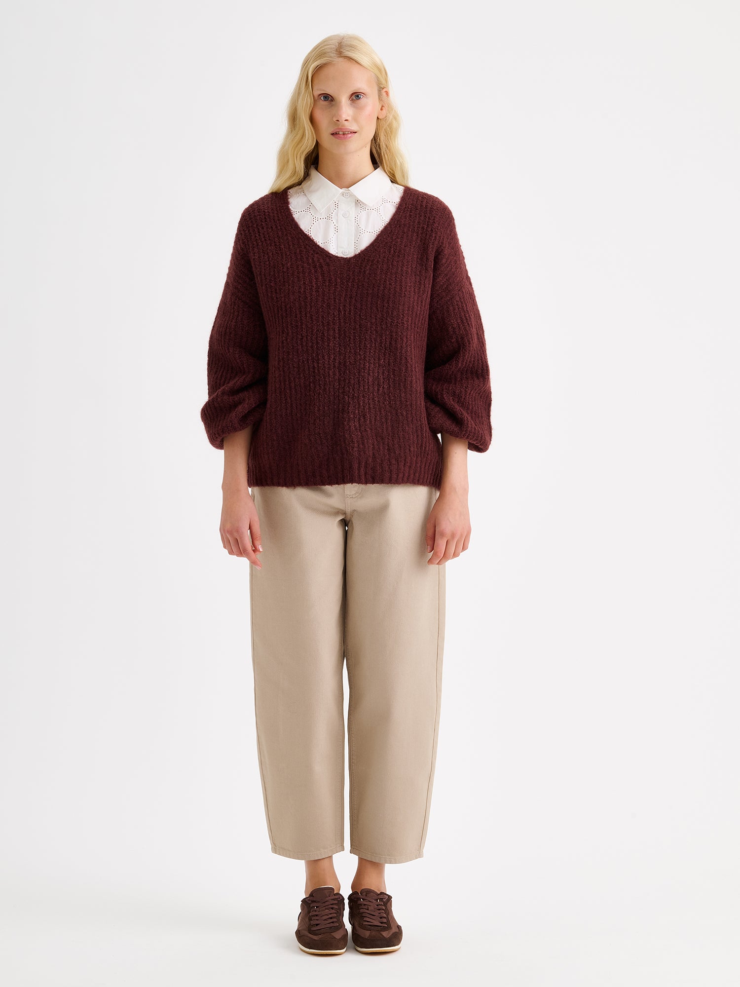 Nanso women's relaxed barrel leg Rento jeans in beige with an effortlessly comfortable fit, on a model with a dark brown knit sweater and a white shirt