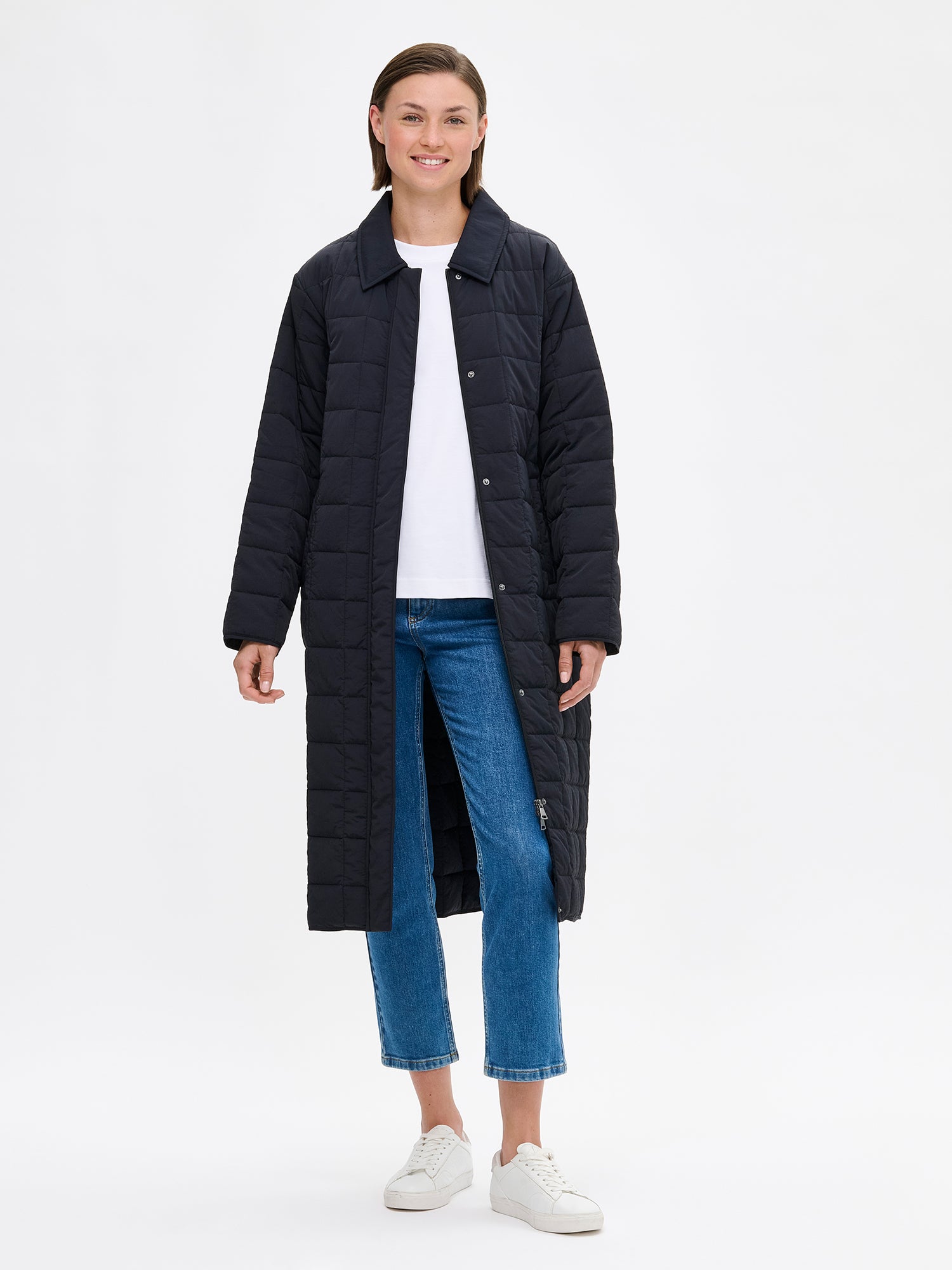 Nanso Marje Quilted Coat features classic collar styling and convenient snap closures at the front, a belt for a personalized fit, and practical front patch pockets. On a model with the coat open.