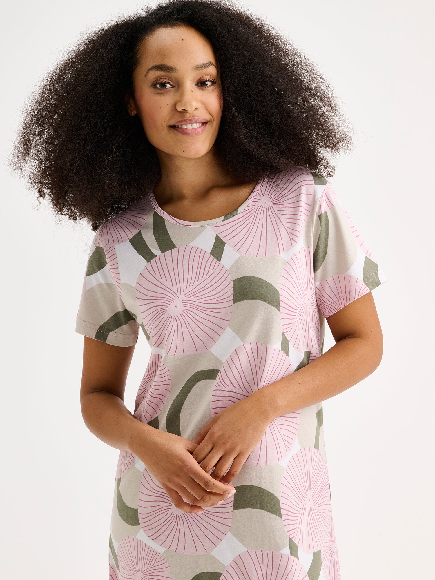 A short Hedda-nightgown in a soft, refreshing pink shade on a model, close-up.