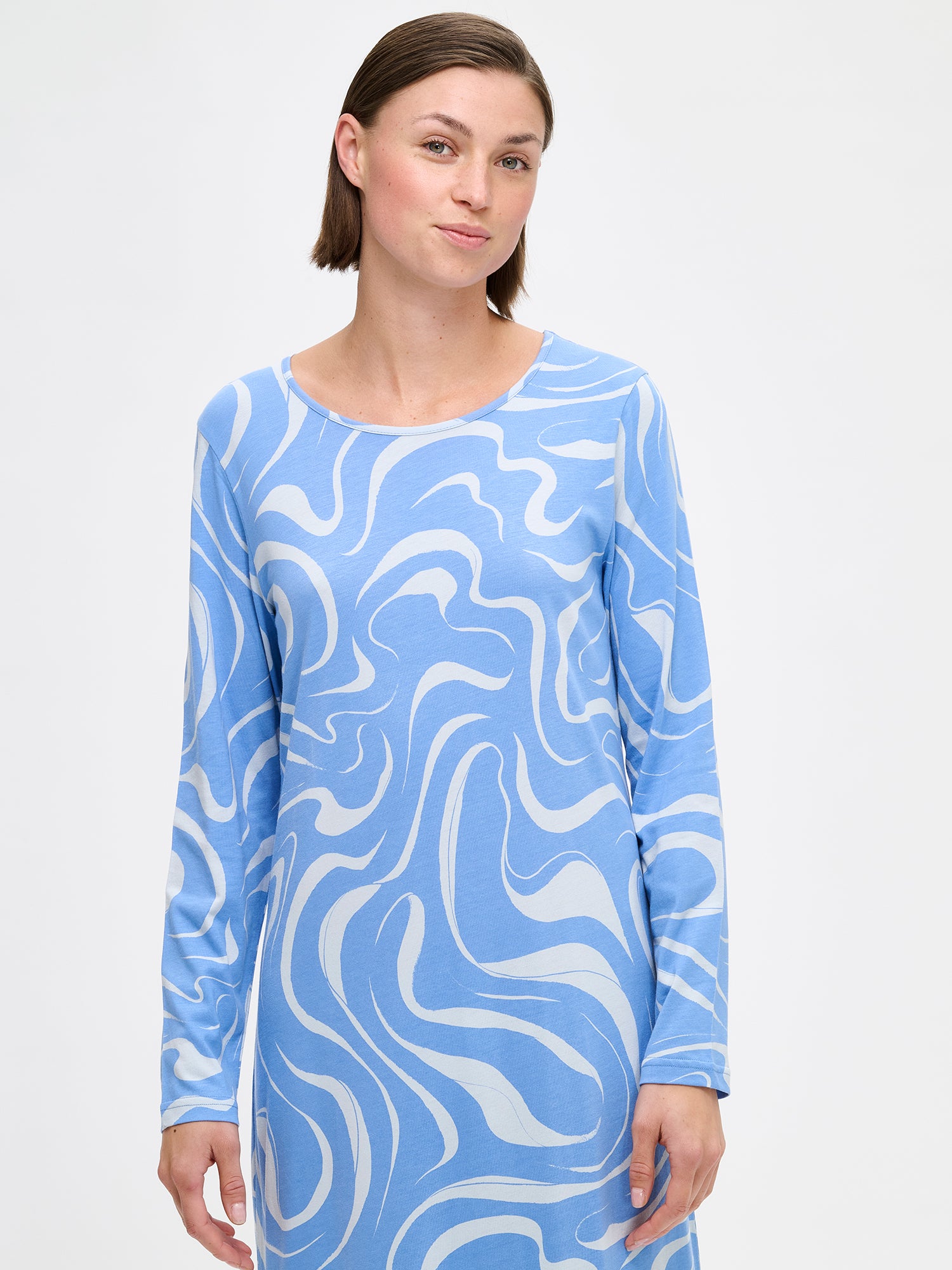 Nanso VESI long-sleeved nightgown blue tones with an elegant patterned design. Features a classic round neckline and relaxed fit and soft material for restful nights. On a model from the front, close-up.