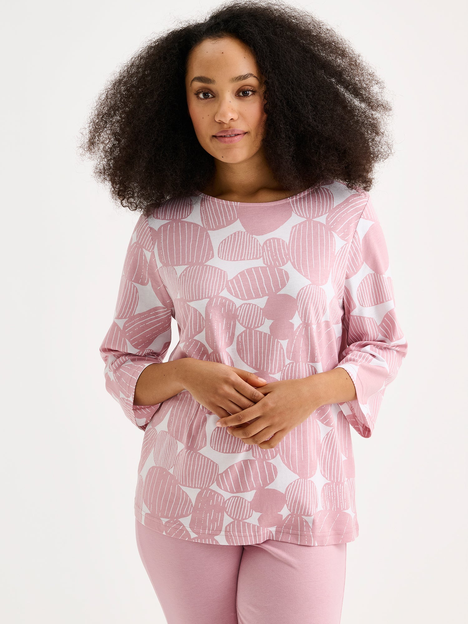 Nanso pink Kummeli pyjamas with 3/4 length sleeves and an oval neckline. The material is high-quality cotton and modal, which feels soft against the skin. Photographed on a model from the front, close-up.