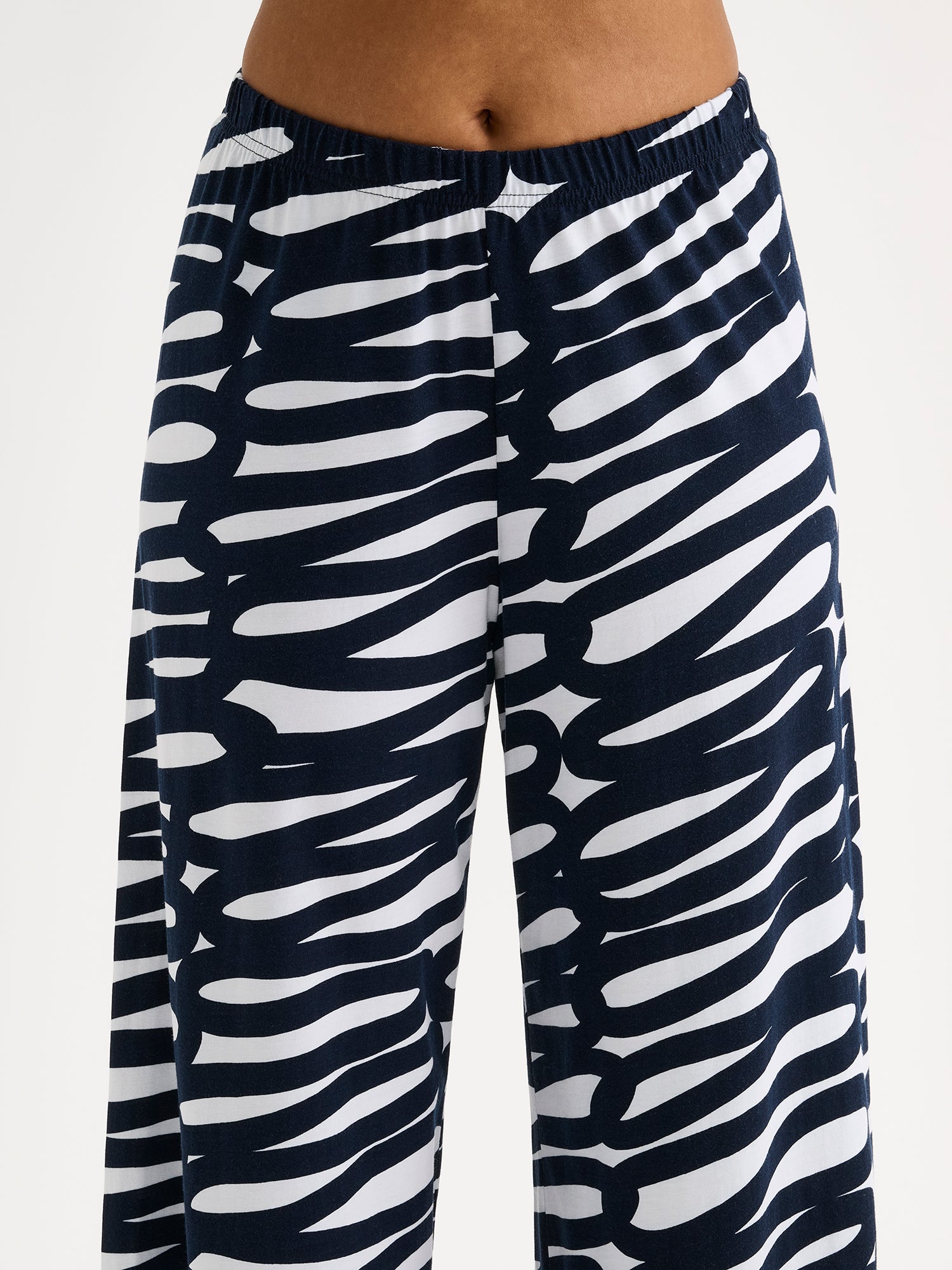 These women's lounge pants feature a striking two-tone pattern that catches the eye, paired with relaxed, wide-leg styling for effortless comfort. Pictured on a model close-up.