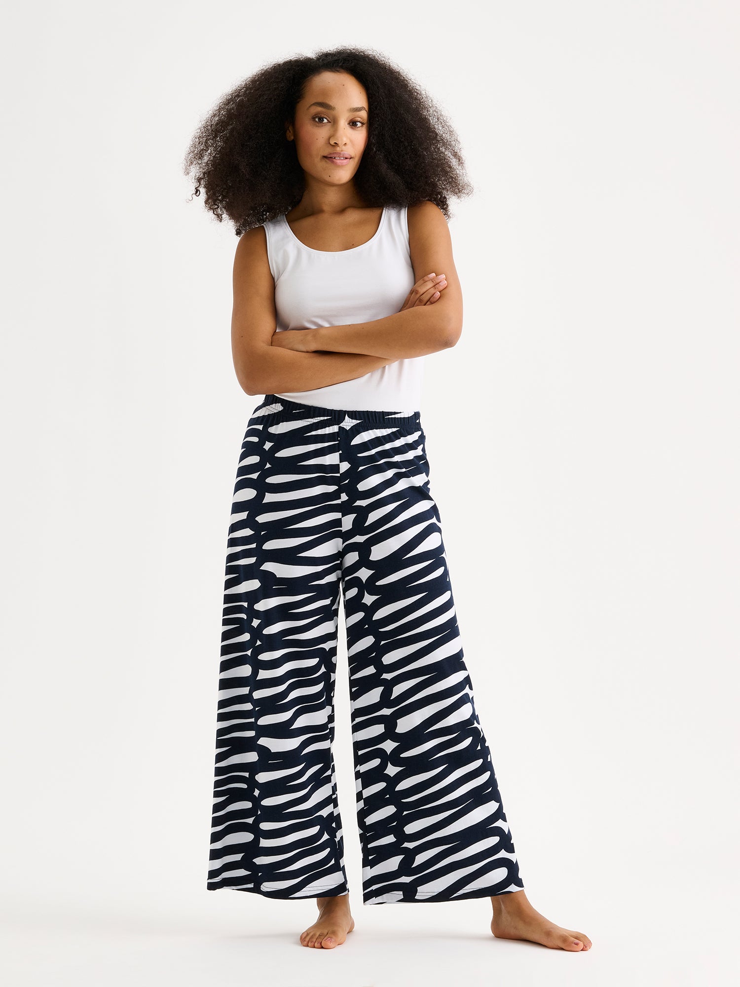 These women's lounge pants feature a striking two-tone pattern that catches the eye, paired with relaxed, wide-leg styling for effortless comfort. Pictured on a model with a white top.