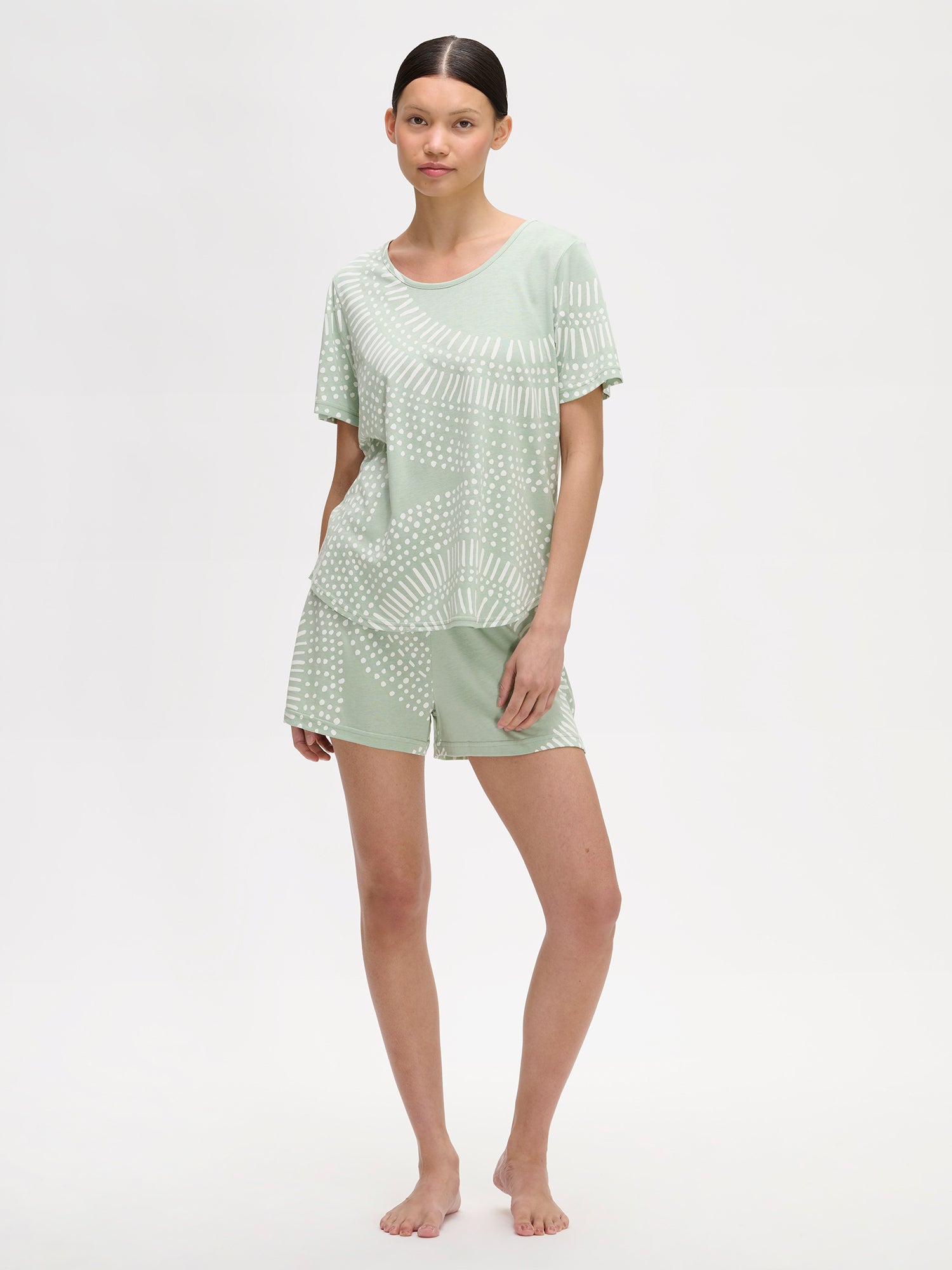 Nanso comfortable light green Aura shorts pyjamas featuring a stylish, harmonious pattern on a model with dark hair.