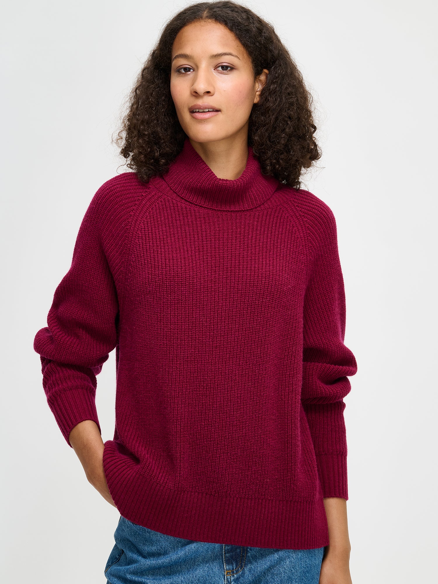 Nanso's Pamela sweater for women is a cozy, burgundy knit featuring a turtleneck and full-length raglan sleeves, close-up
