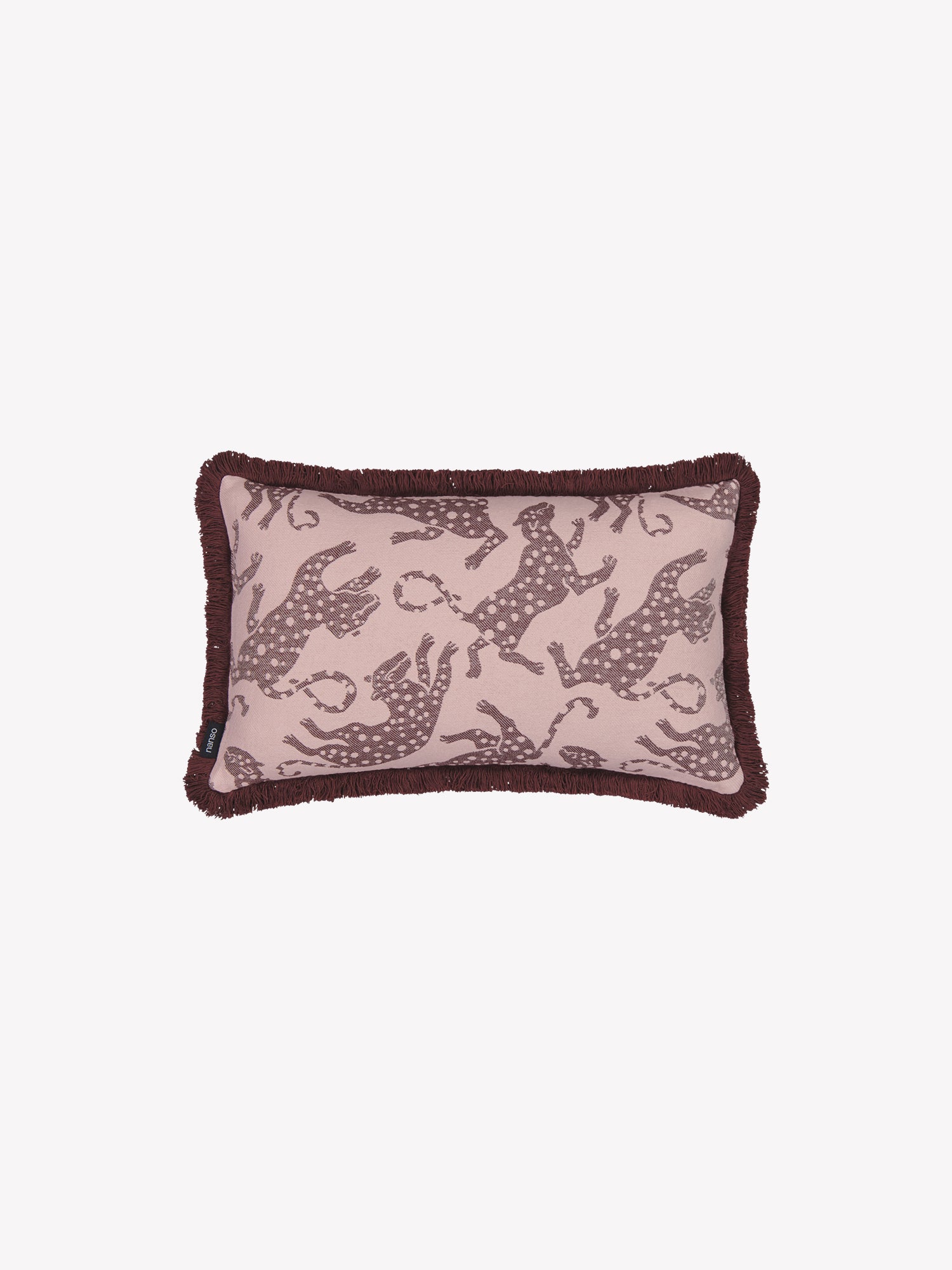 The leopard-print Hapsu pillowcase in a soft rose shade with red tassels along the edges in a product picture.