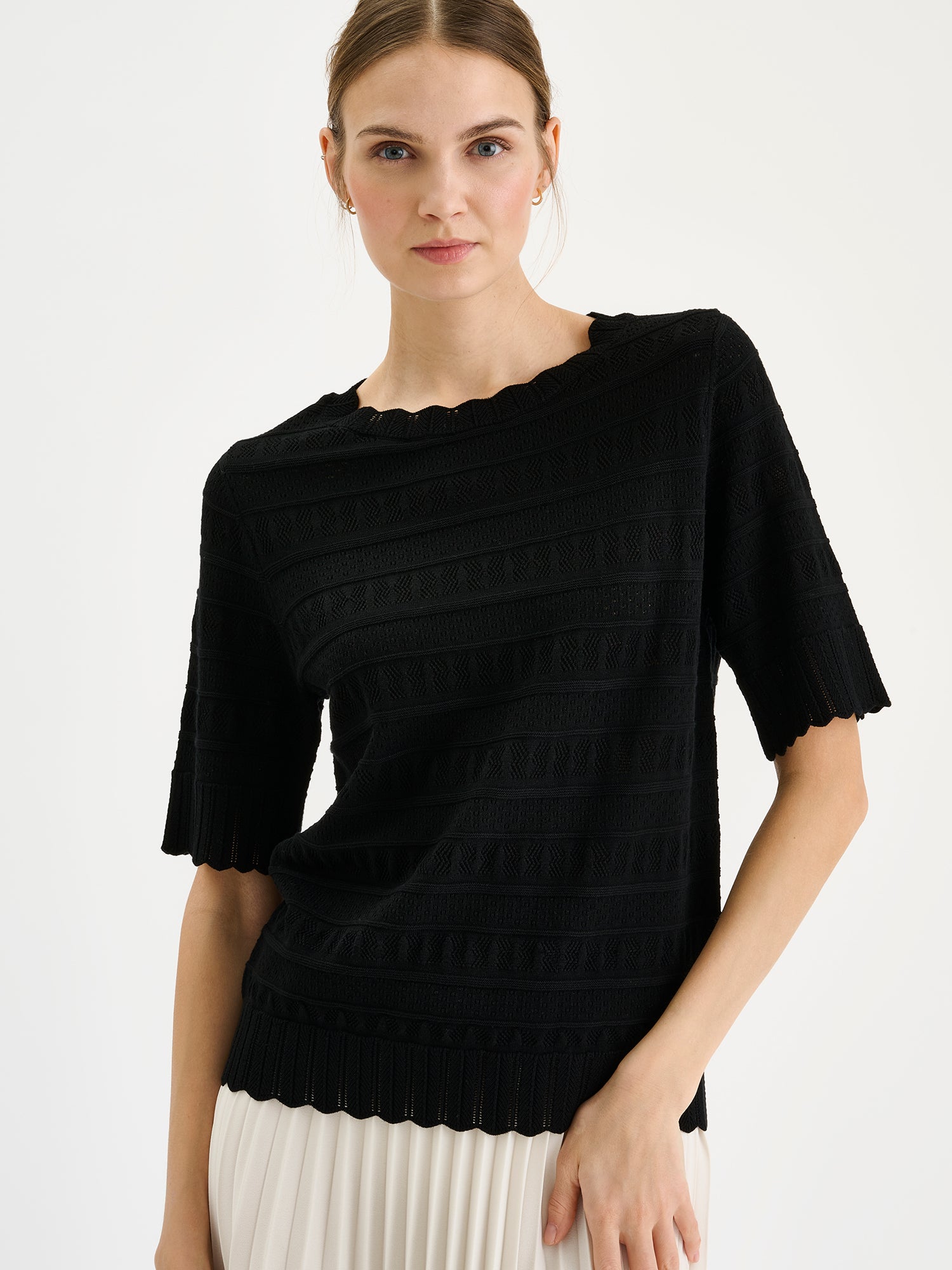 Nanso timeless black KORU knit sweater featuring delicate lace knit on a model, close-up.