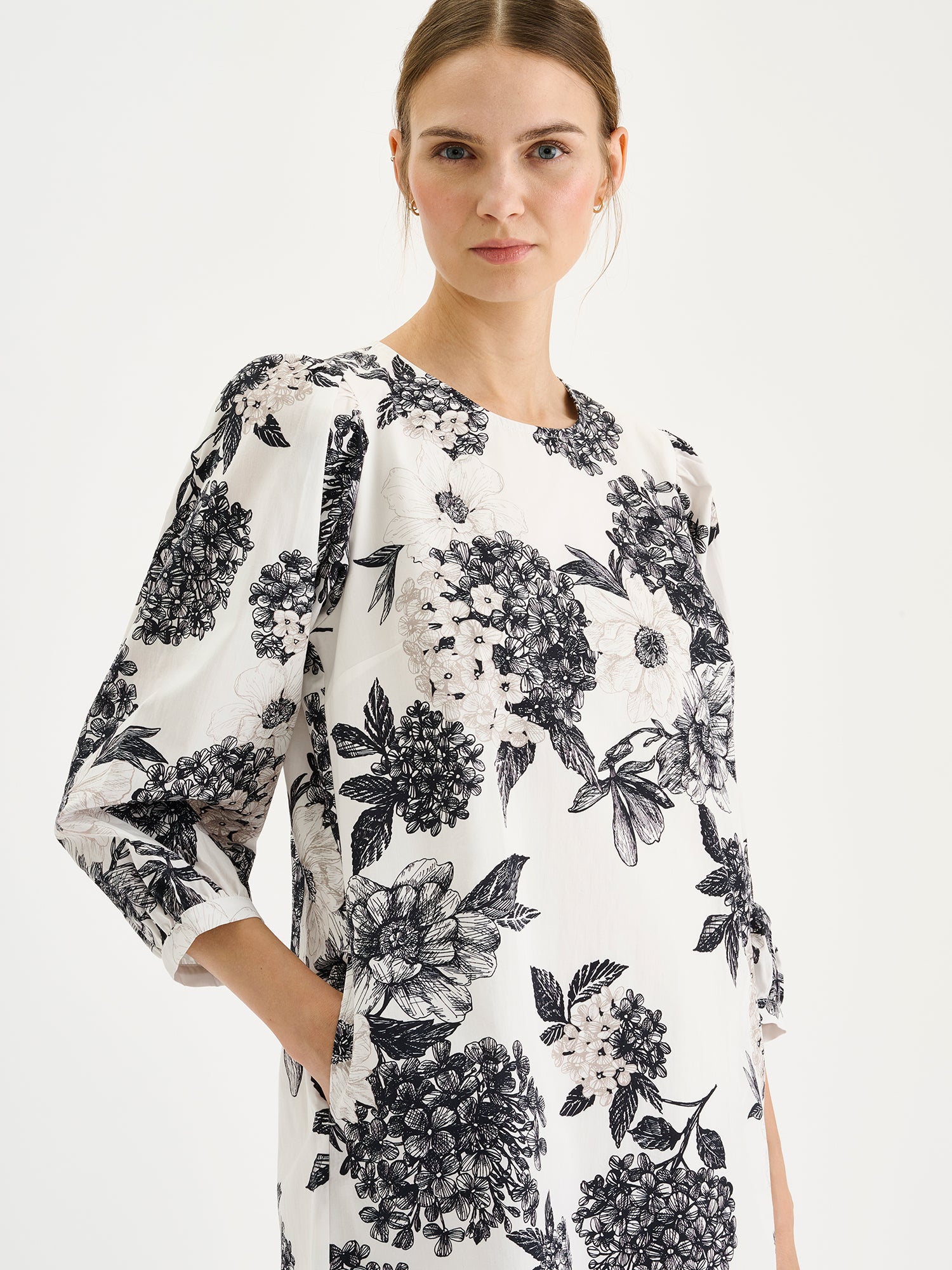 Nanso Palatsi Dress in a striking black and white floral pattern on a model, close-up.