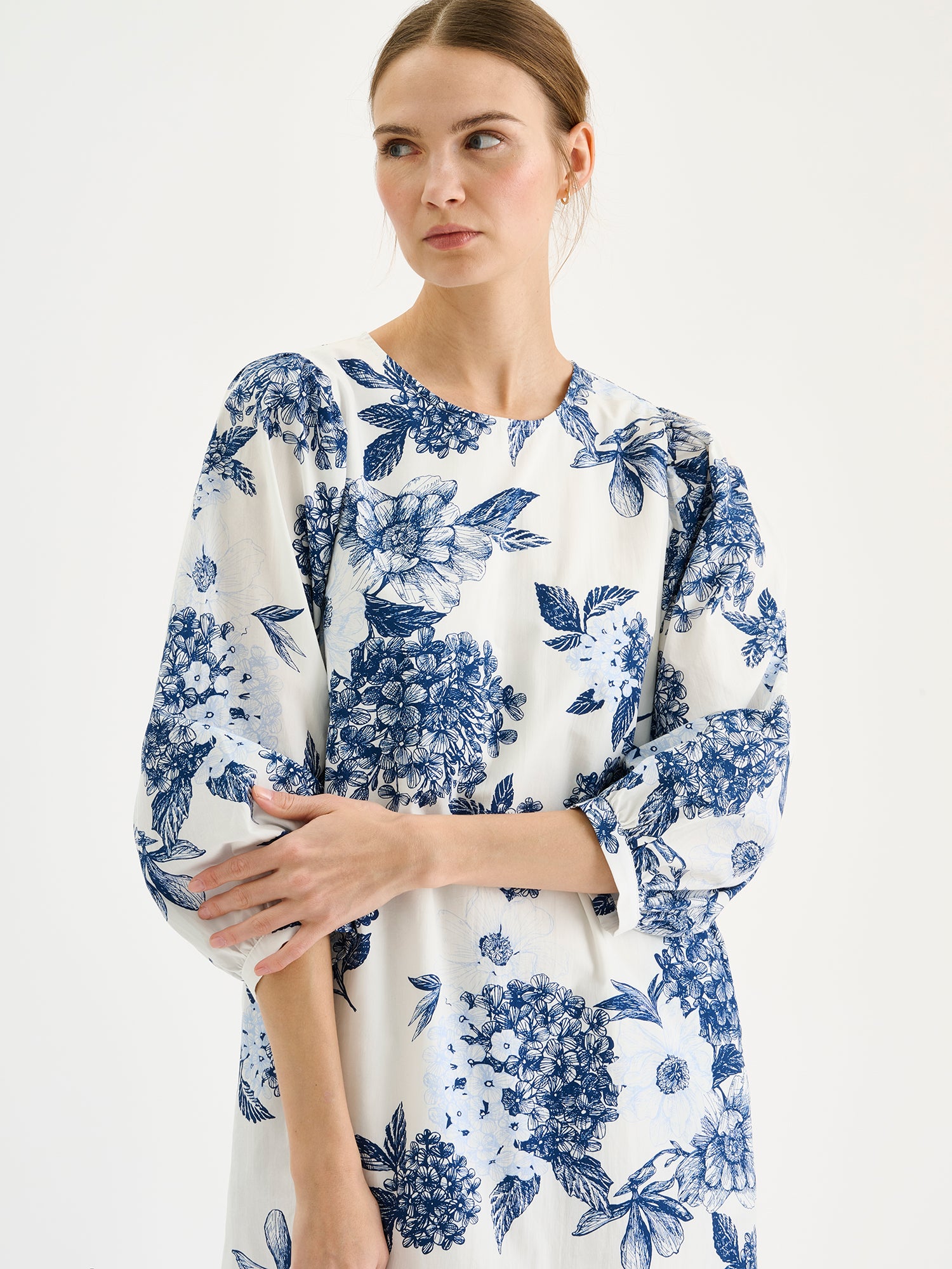 Nanso Palatsi Dress in a striking blue and white floral pattern on a model, close-up.