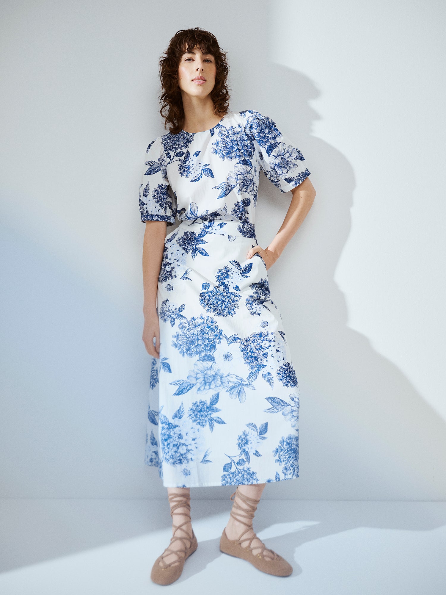Nanso charming floral patterned Palatsi skirt, featuring a striking blue and white pattern on a model with a matching blouse.
