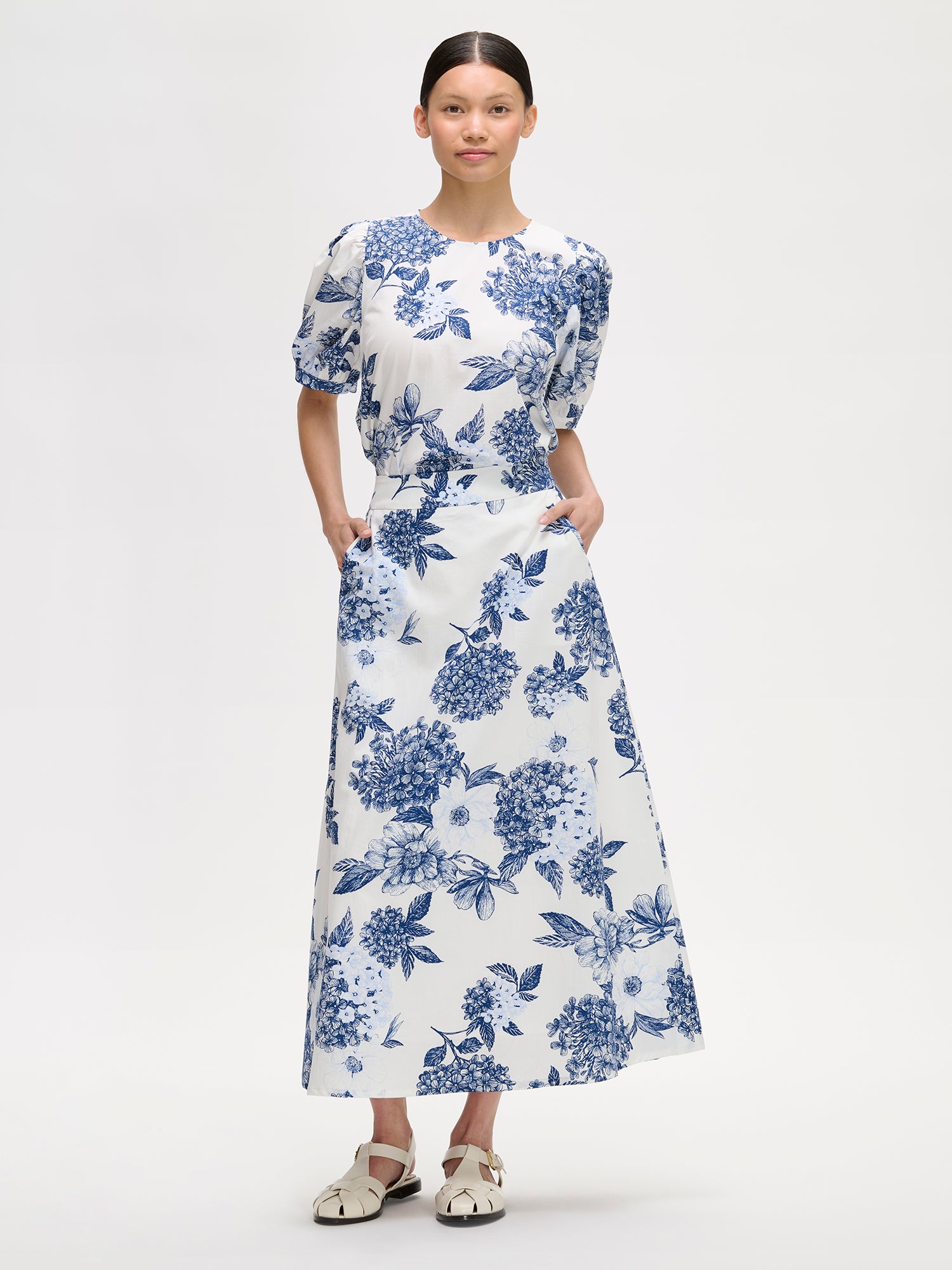 Nanso charming floral patterned Palatsi skirt, featuring a striking blue and white pattern on a model with a matching blouse.
