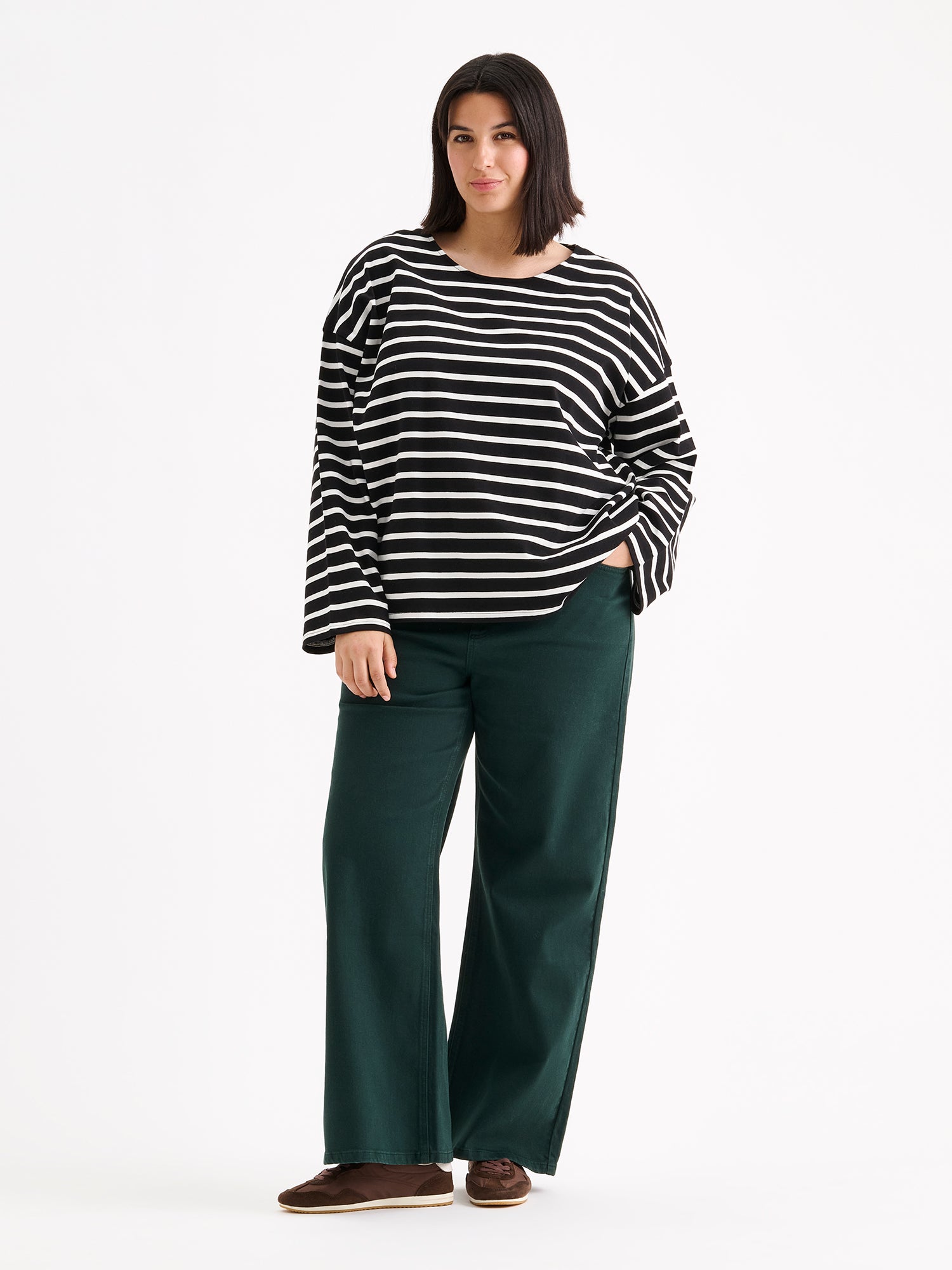 Nanso women's black and white striped long-sleeved Breton blouse with a relaxed, effortless fit, on a model with dark green jeans.