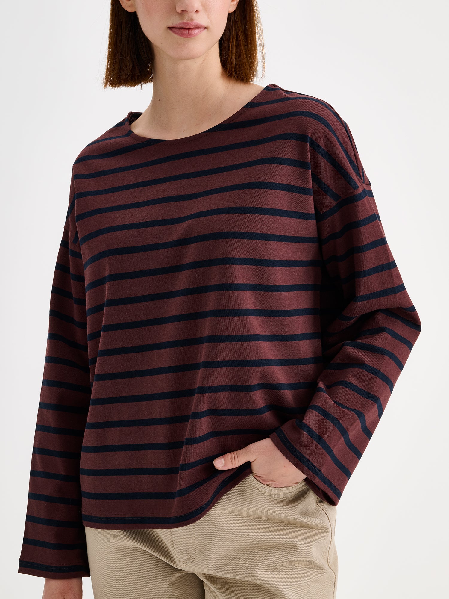 Nanso women's dark brown striped long-sleeved Breton blouse with a relaxed, effortless fit, on a model with beige barrel style jeans, close-up.