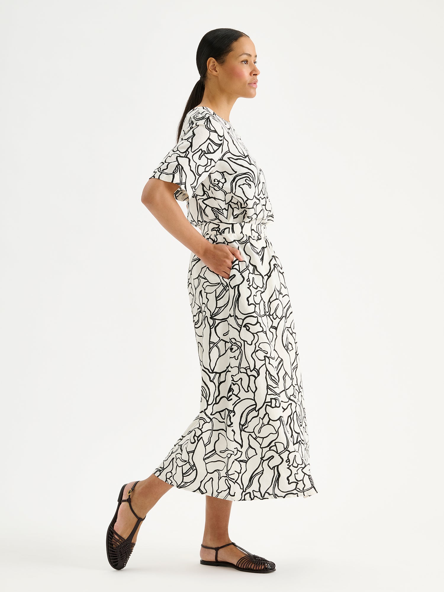 Nanso women's stylish and wonderfully relaxed IIRIS blouse featuring half-length sleeves and an elegant black and white floral pattern on a model a matching skirt.