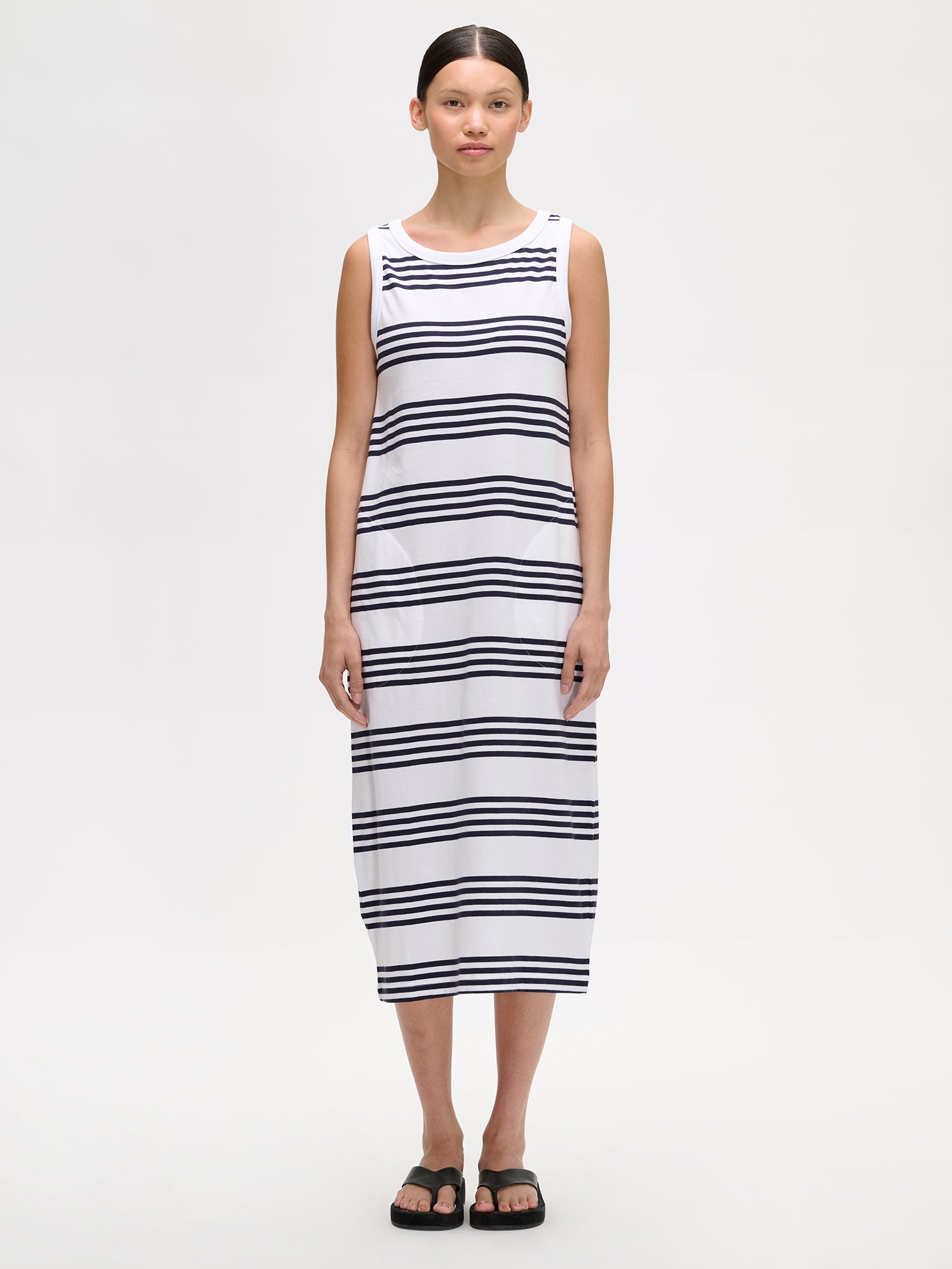 Nanso women's MERINA Dress is a fresh, striped navy and white midi dress that's a timeless classic for everyday and holiday wear. Pictured on a model