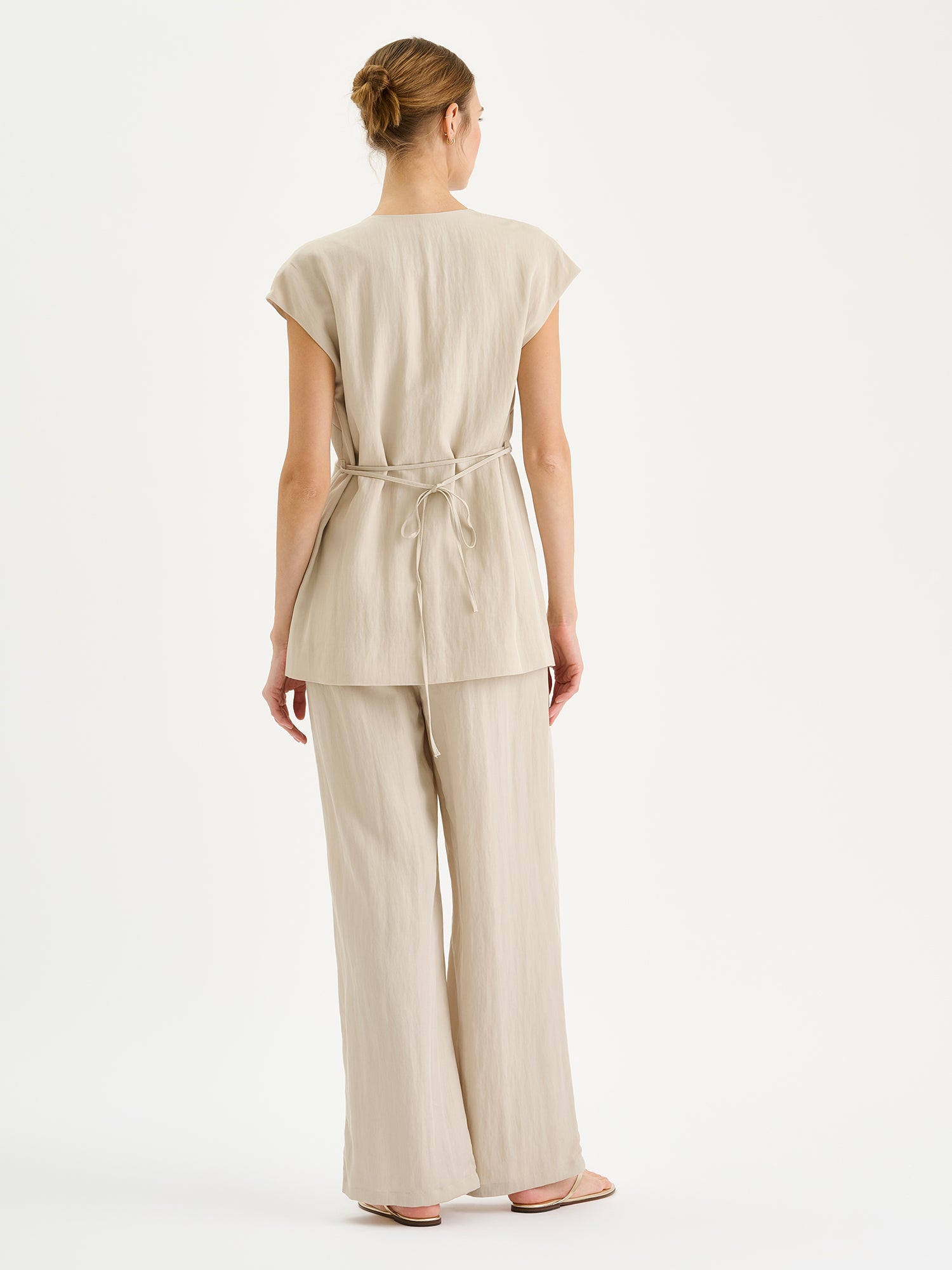 Nanso sophisticated beige waistcoat from the NIZZA collection on a model with matching trousers pictured from the backside