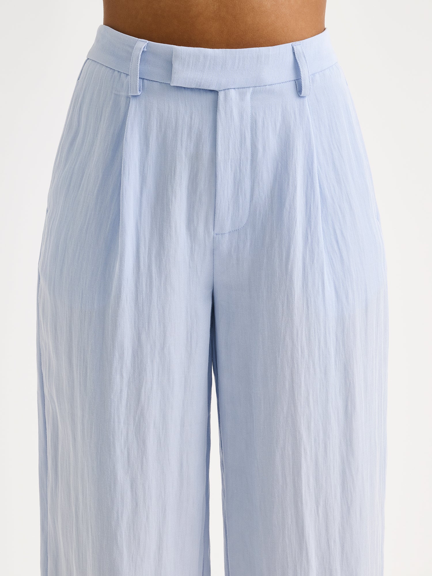 Nanso Nizza trousers in a sophisticated blue shade on a model, close-up.