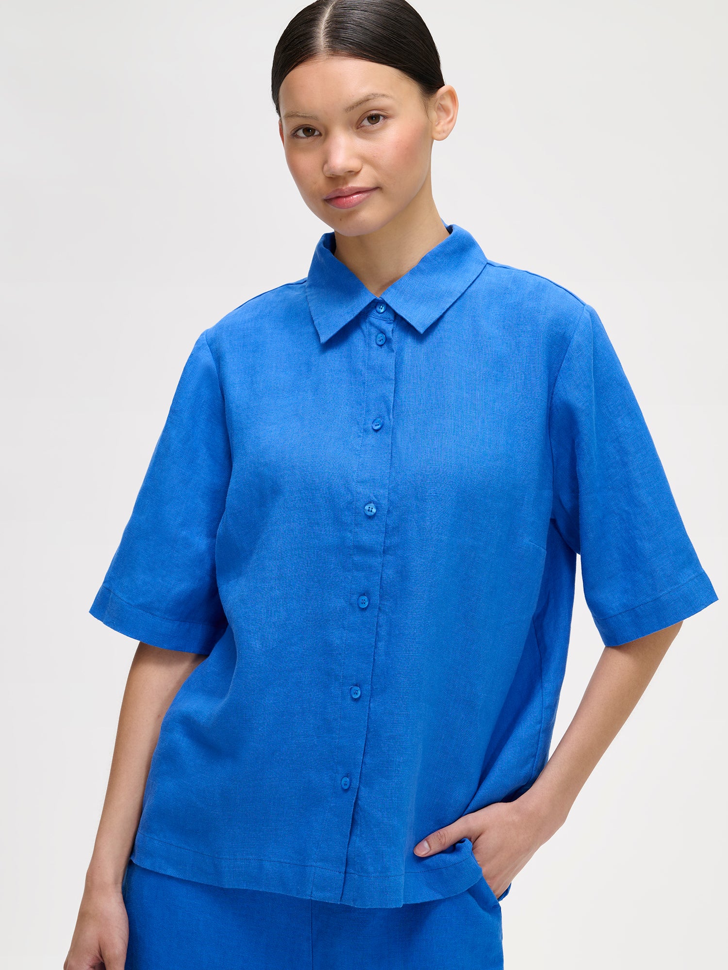 Nanso women's relaxed blue Liine linen shirt, crafted from breathable linen on a model with matching shorts, close-up.