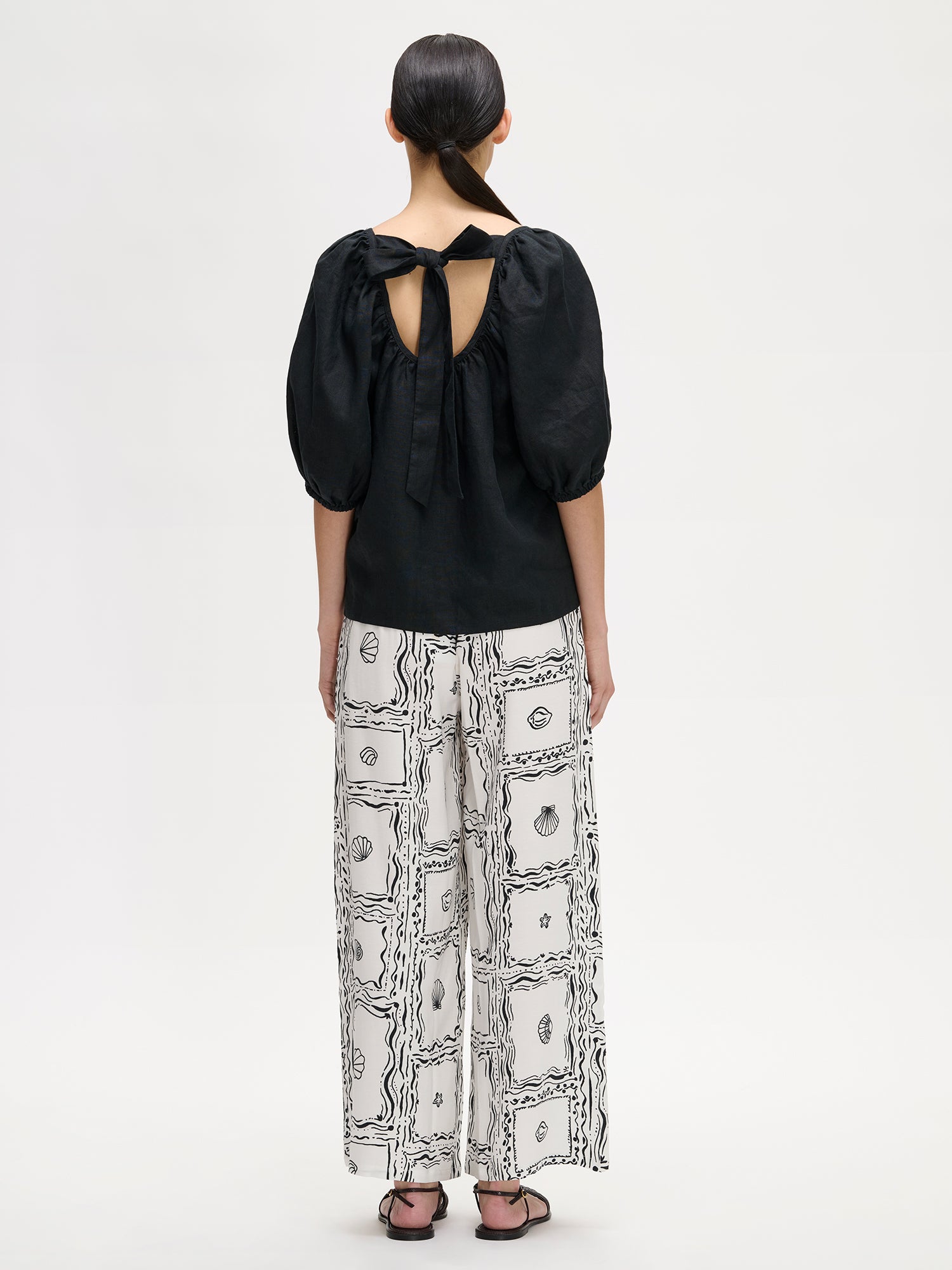 Nanso women's Donna linen blouse in black, on a model with wide patterned trousers, picture from the backside