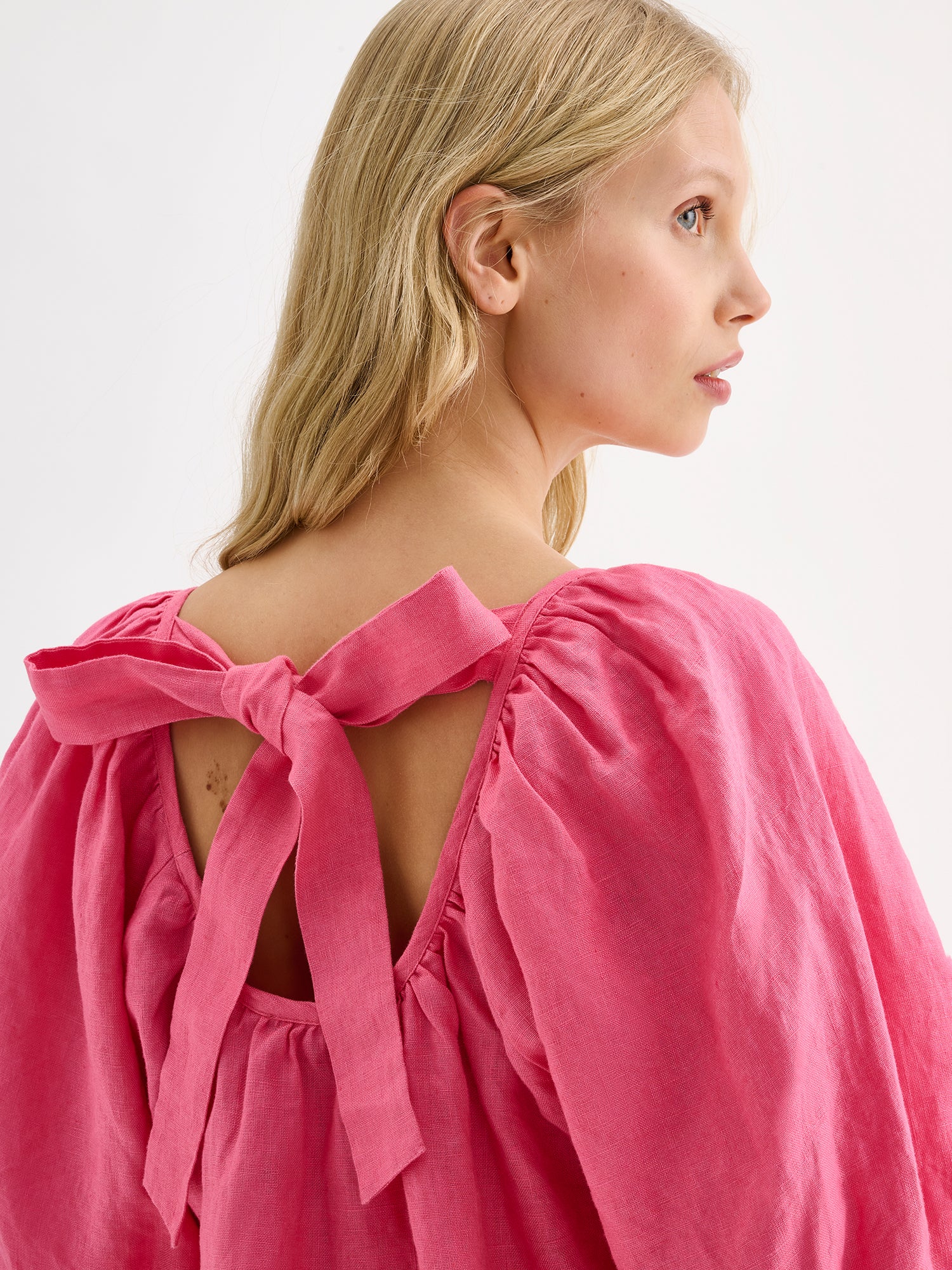 Nanso women's Donna linen blouse in a delicious pink shade on a model, close-up from the backside