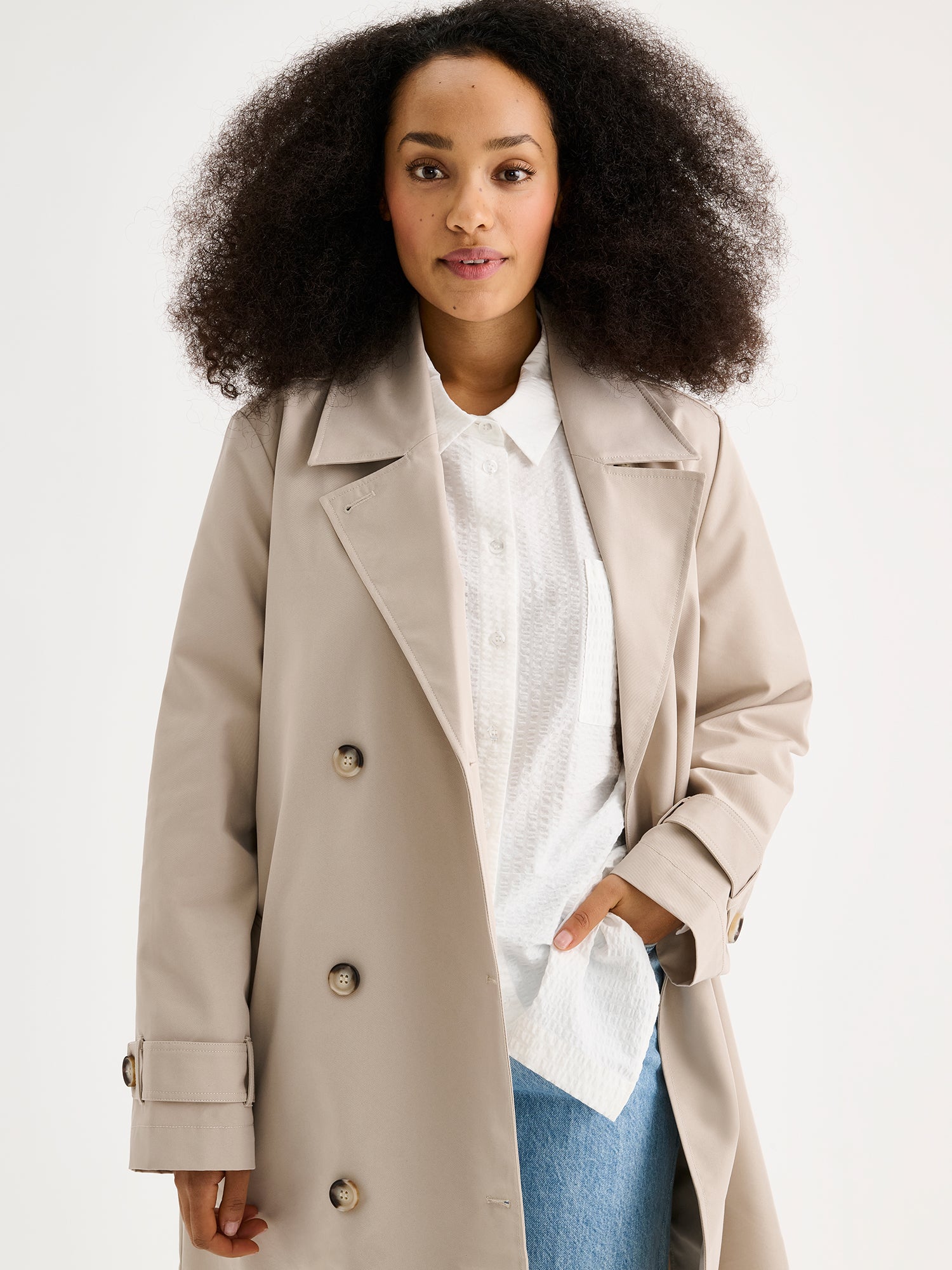 Nanso women's timeless midi trench coat in beige on a model with jeans, close-up