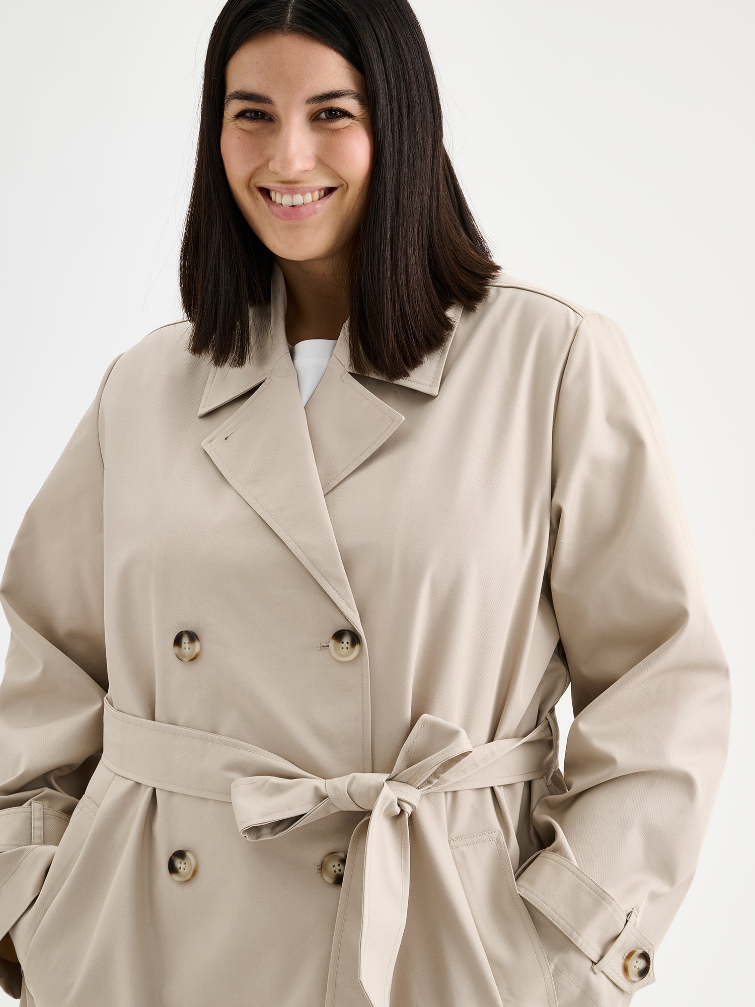 Nanso women's timeless midi trench coat in beige on a model, close-up.