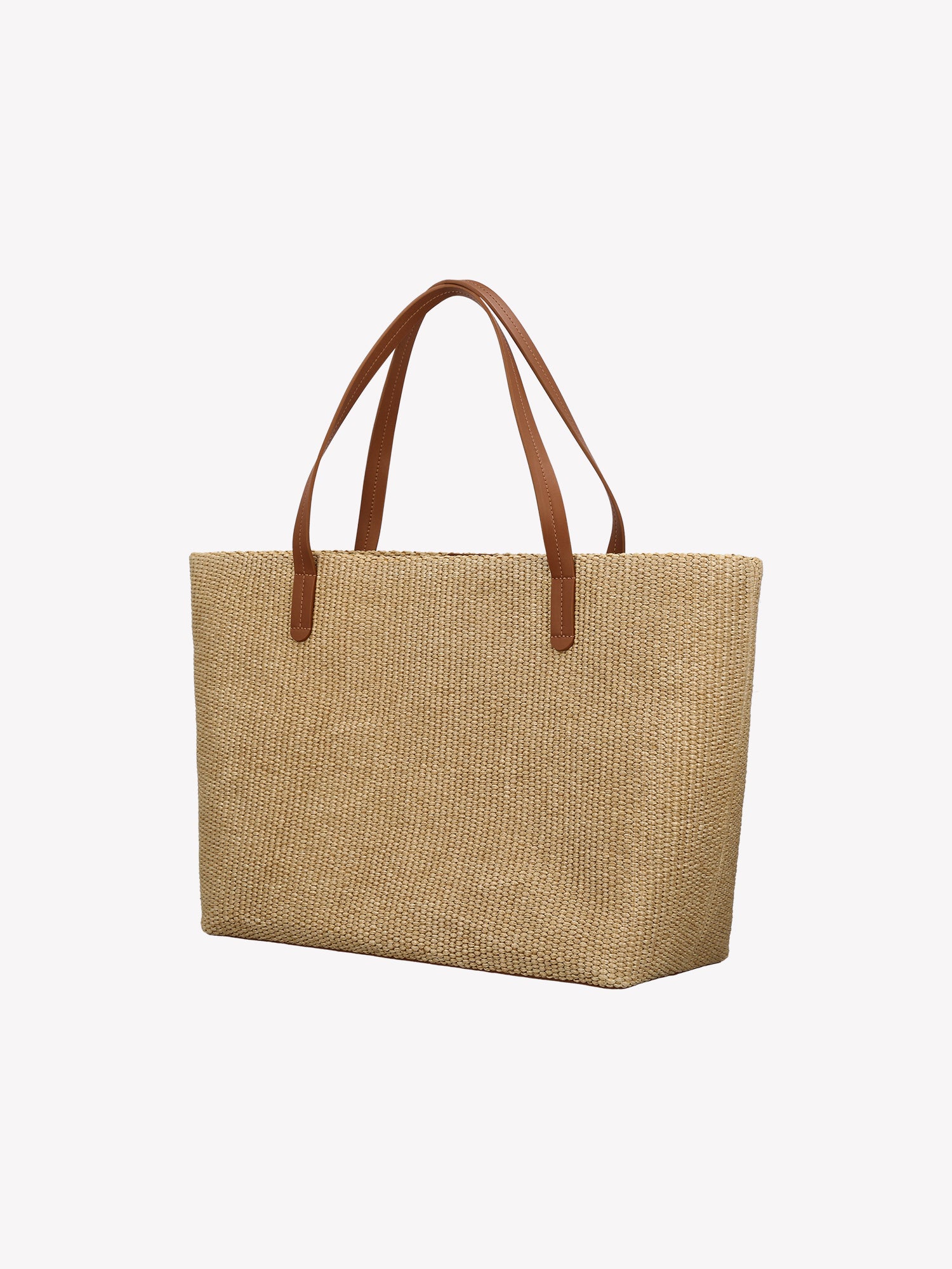 Crafted from durable straw-like material with genuine leather handles, the KORI TOTE Bag combines natural texture with refined style.  The KORI TOTE features a cotton lining. Product picture from the back.