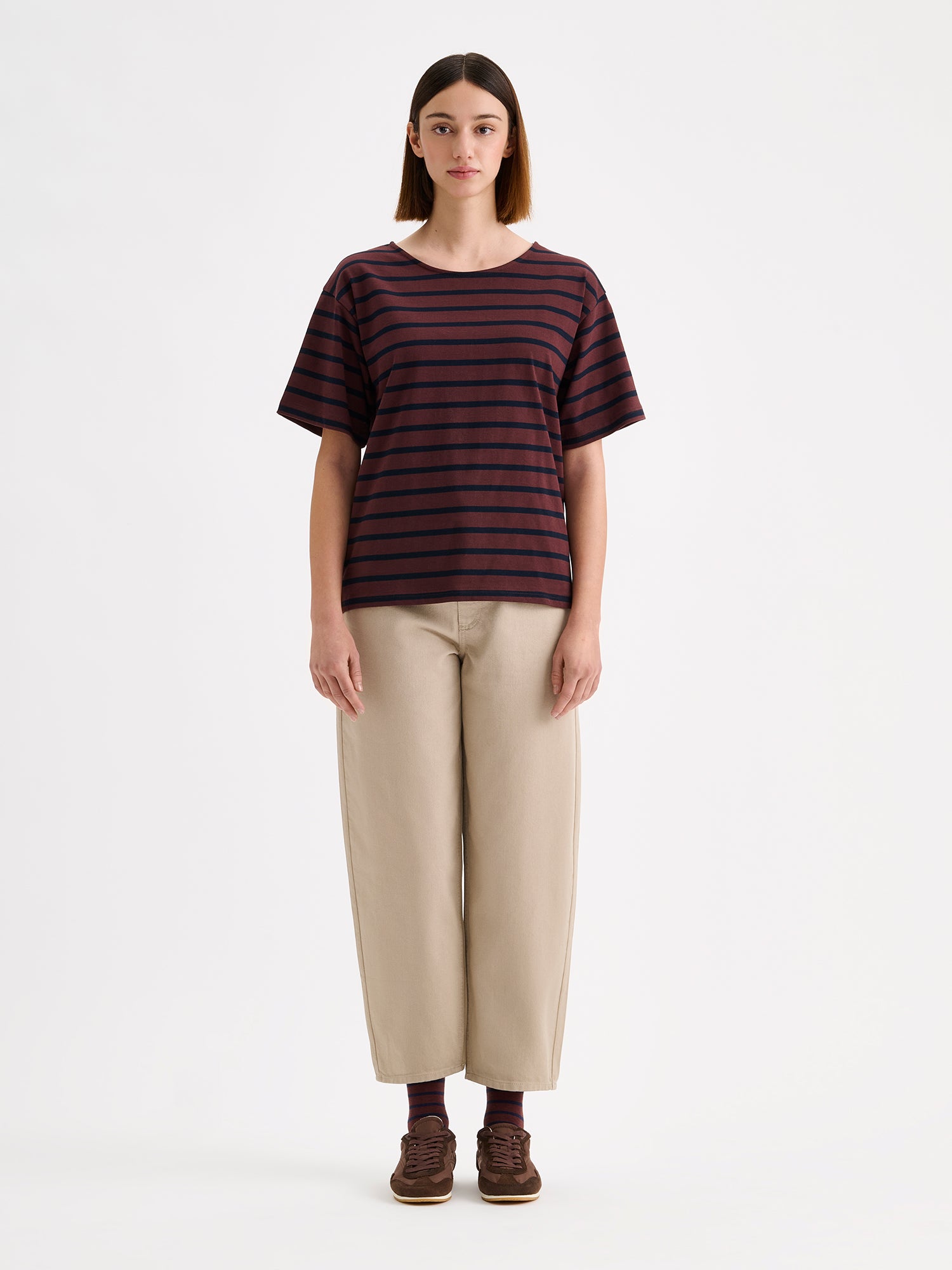 Nanso timeless brown striped short-sleeved Breton T-shirt, on a model with beige barrel leg jeans.