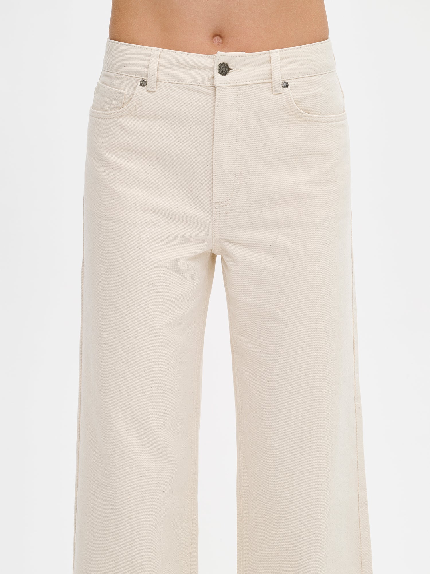 Nanso women’s trendy off white Cropped Levee jeans with a high waist, on a model from the front, close-up.
