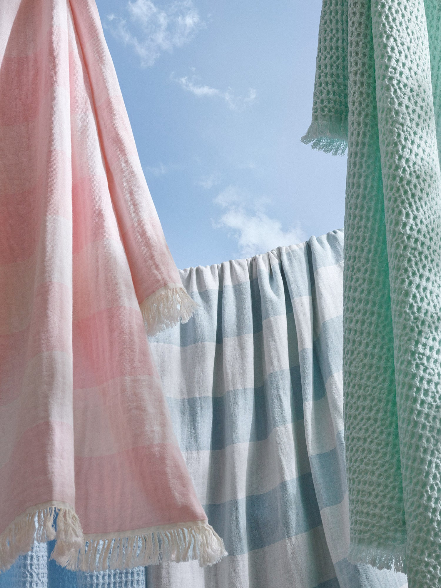 Nanso's pastel coloured towels pictured against a blue sky.