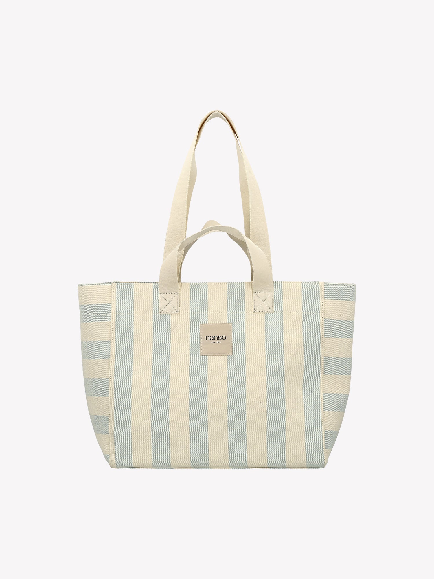 The Amalfi Beach bag brings effortless style to your adventures with its crisp light blue and white striped design. Crafted from durable fabric with dual handles. Product picture from the front.